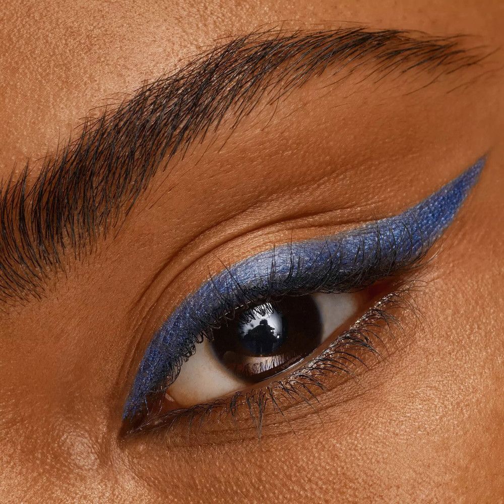 Gros plan sur un œil avec un trait d'eye-liner bleu. L'œil est ouvert.