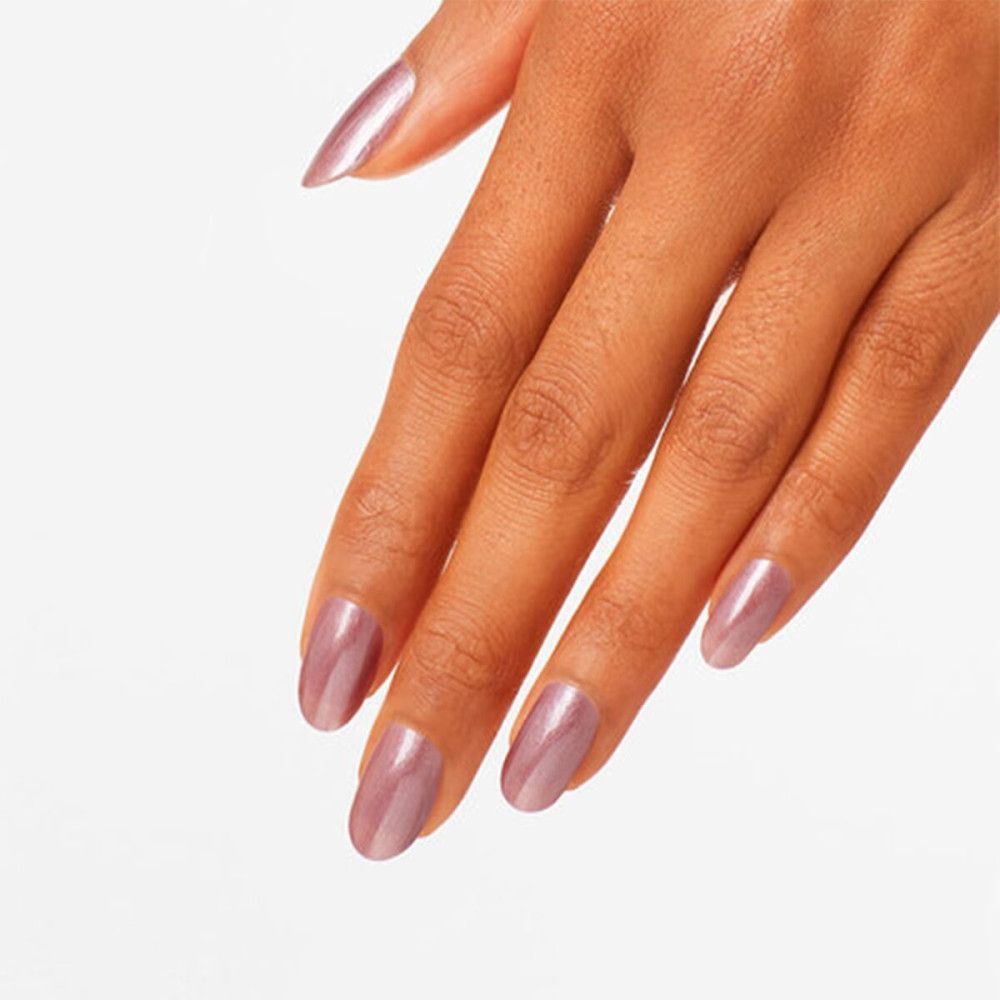 Main avec ongles vernis en rose. Forme ovale, brillant.