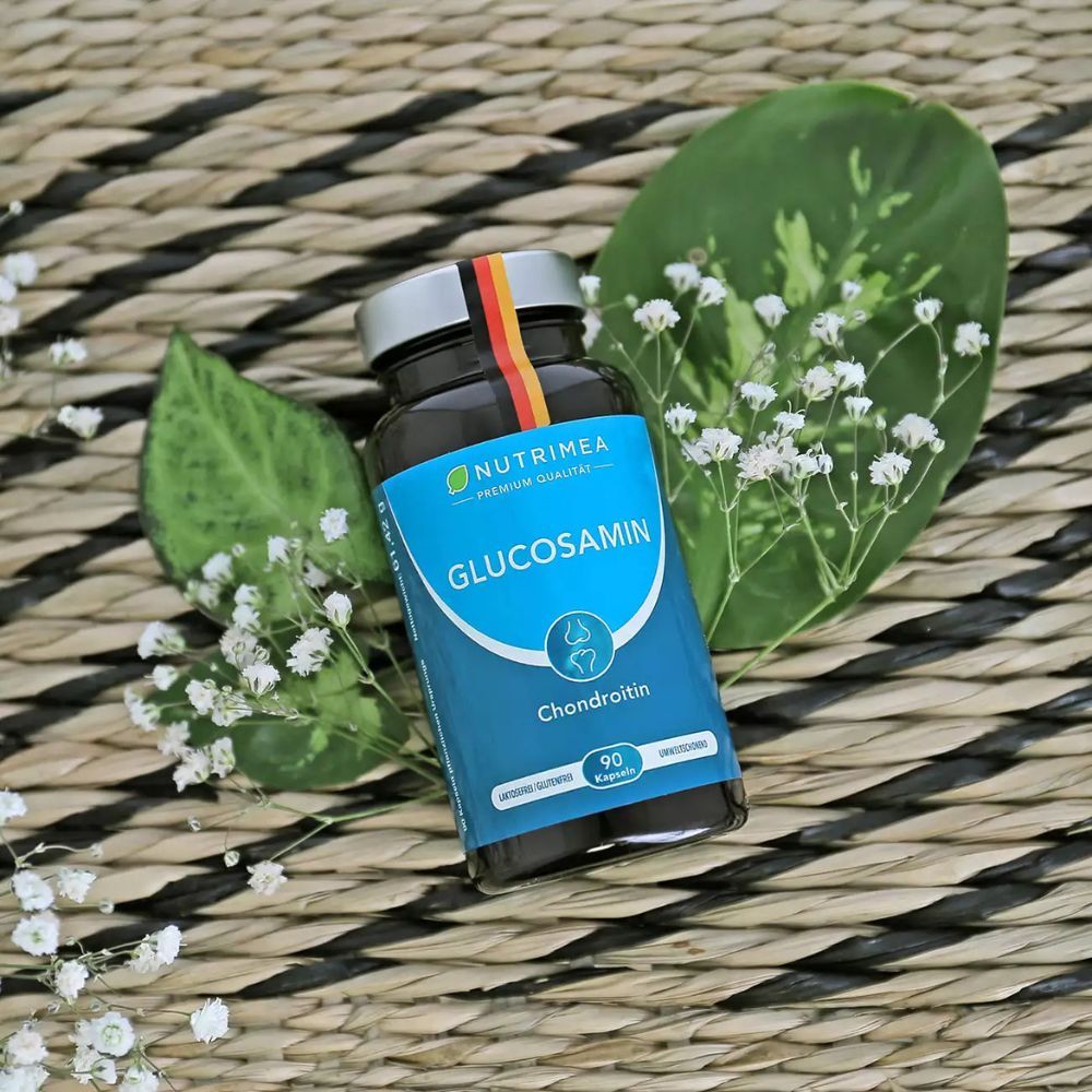 Fles met Glucosamine, Chondroïtine. Geplaatst op een mand met bladeren en bloemen. 90 capsules.