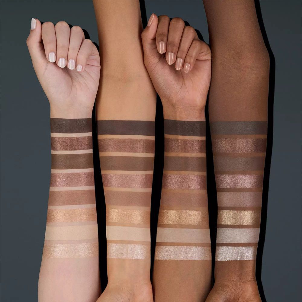 Vier armen met verschillende huidtinten, elk met acht oogschaduwkleuren aangebracht. De kleuren variëren van licht tot donker.