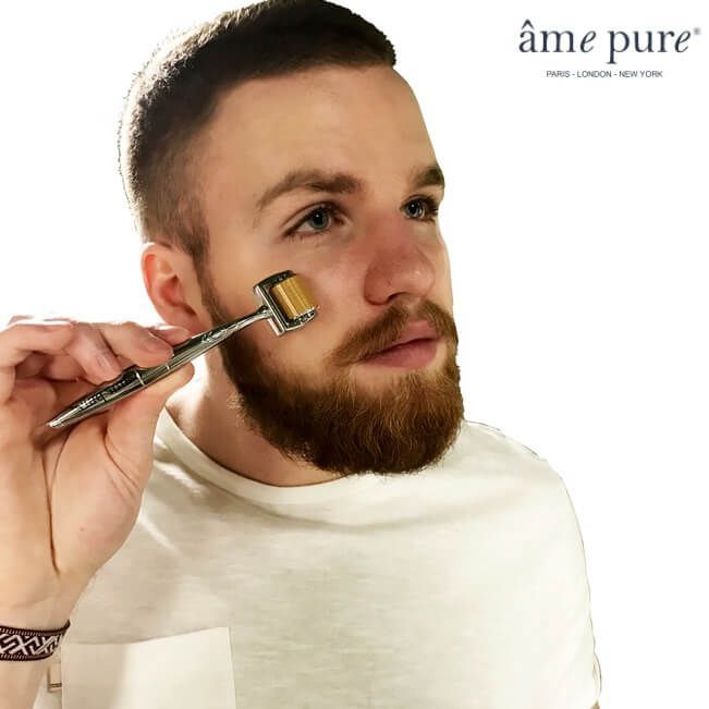 Man die een microneedling roller op zijn gezicht gebruikt.