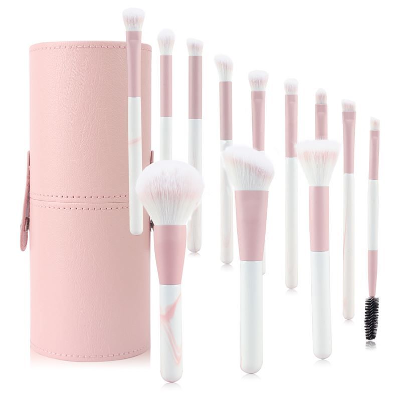 Ensemble de pinceaux de maquillage avec étui rose. Pinceaux avec manches roses et blancs. Différentes formes et tailles. Comprend également une brosse à cils.