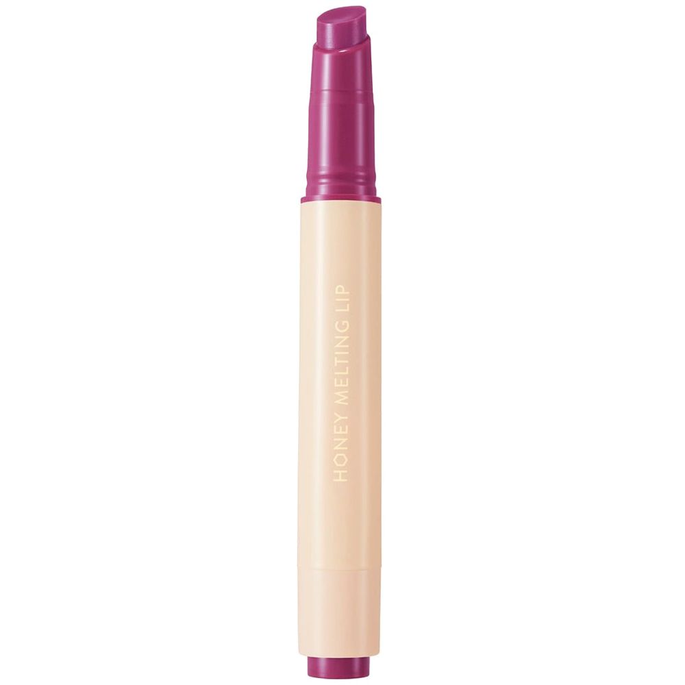Honey Melting Lip Gloss. Le rouge à lèvres a une base crème et un capuchon violet. Texte: HONEY MELTING LIP.