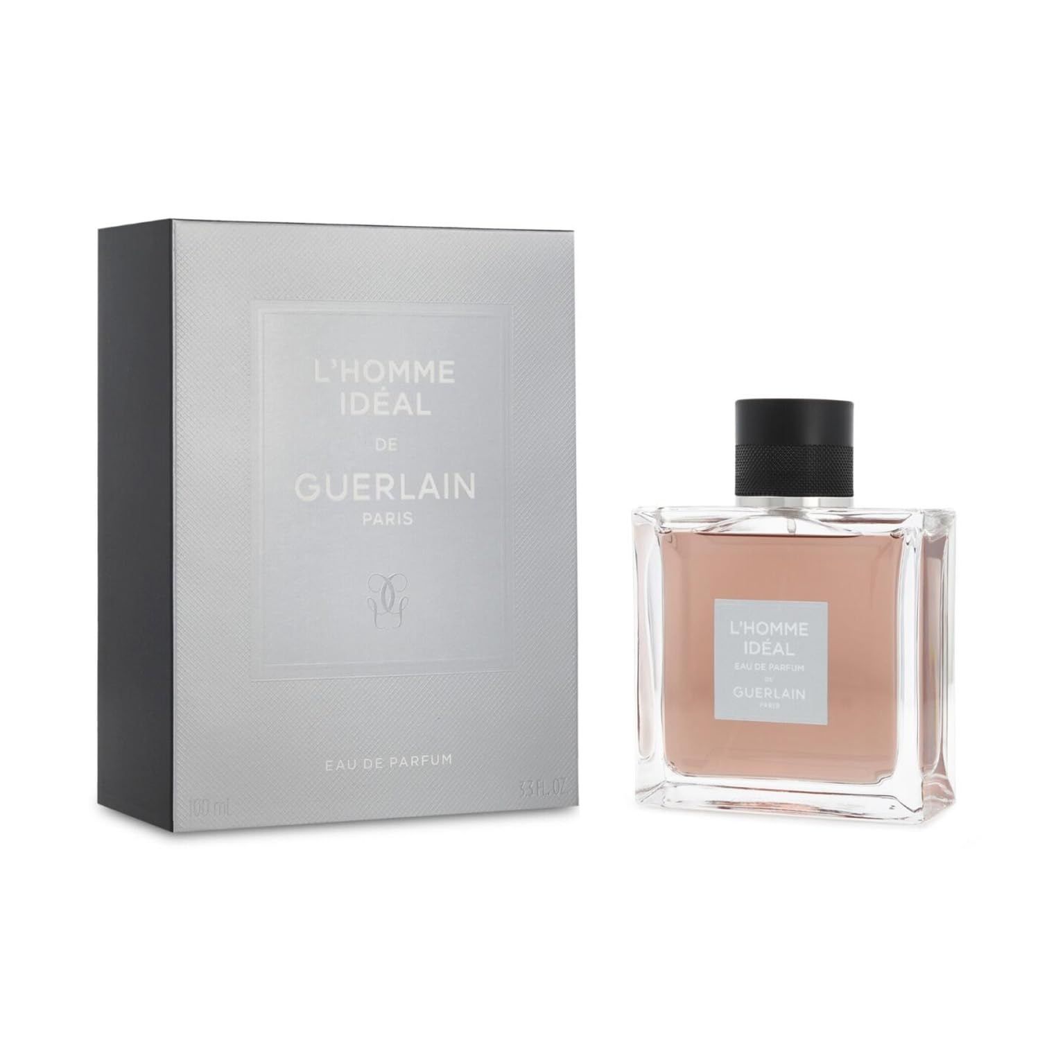 Fles en verpakking. Opschrift: L'Homme Ideal de Guerlain Paris. Vierkante fles, roze vloeistof, zwarte dop. Zilveren verpakking.