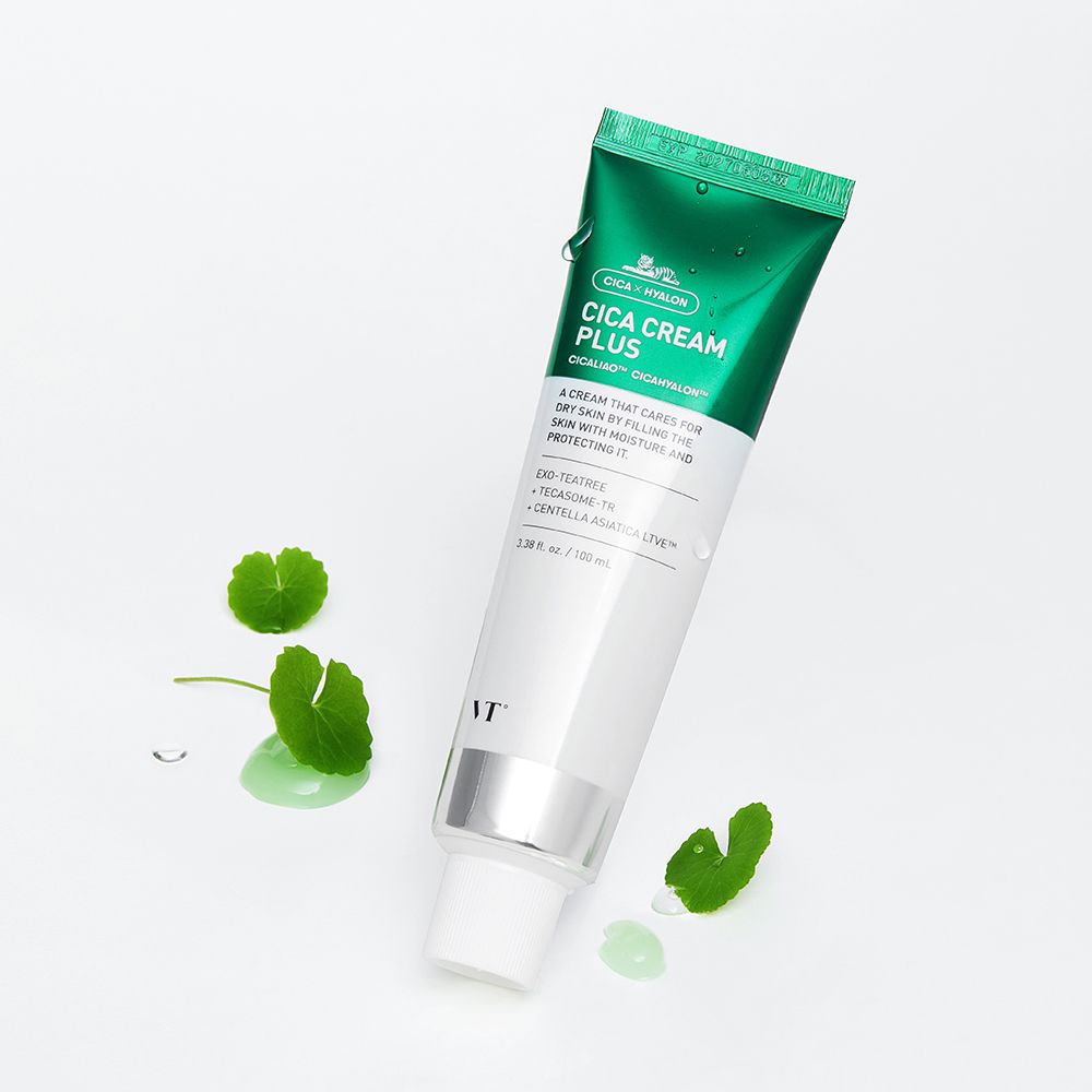 Tube de Cica Cream Plus. Tube vert et blanc avec bouchon vert. Inscription Cica Cream Plus. Feuilles et gouttes.