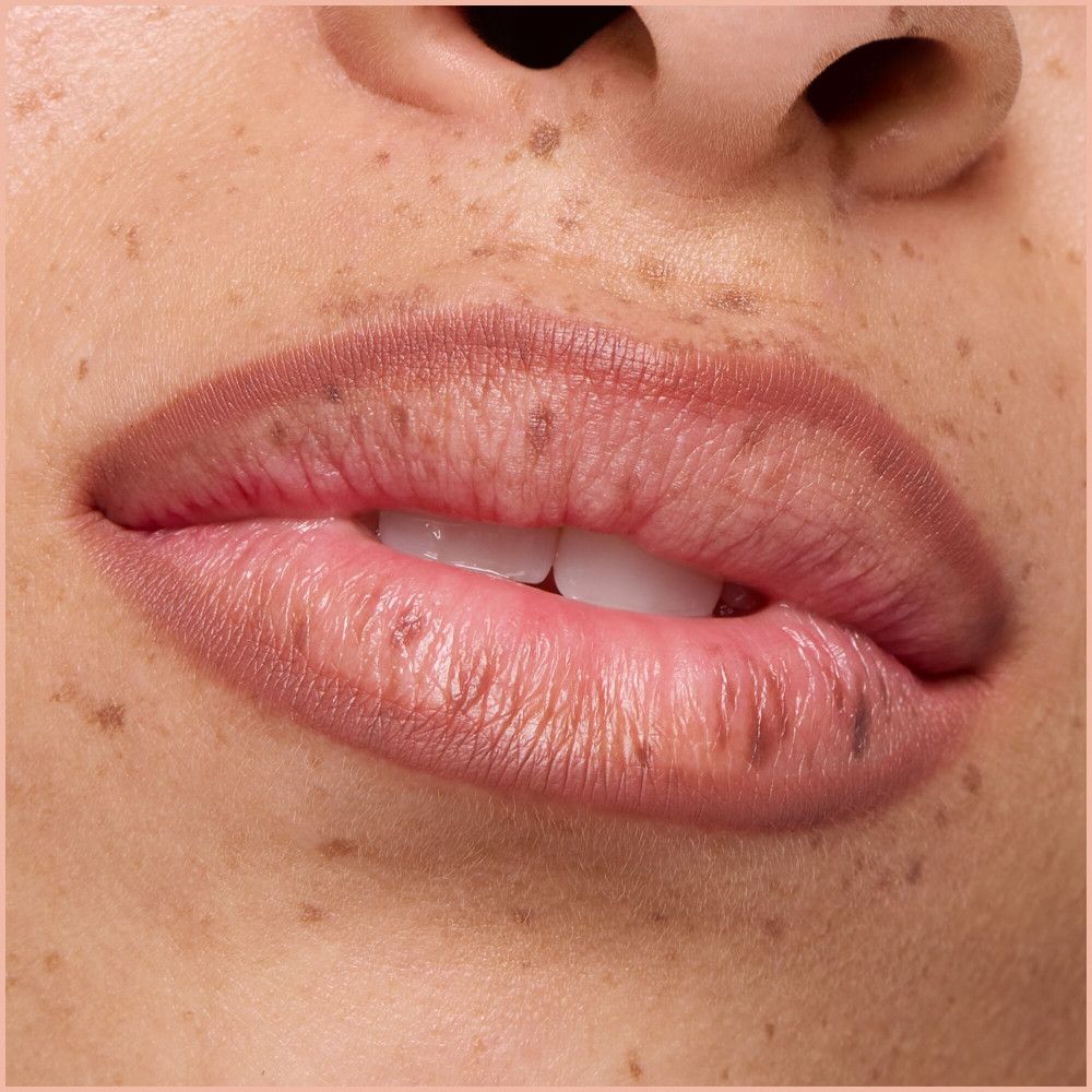 Close-up van lippen met lippenstift. Huid met sproeten.