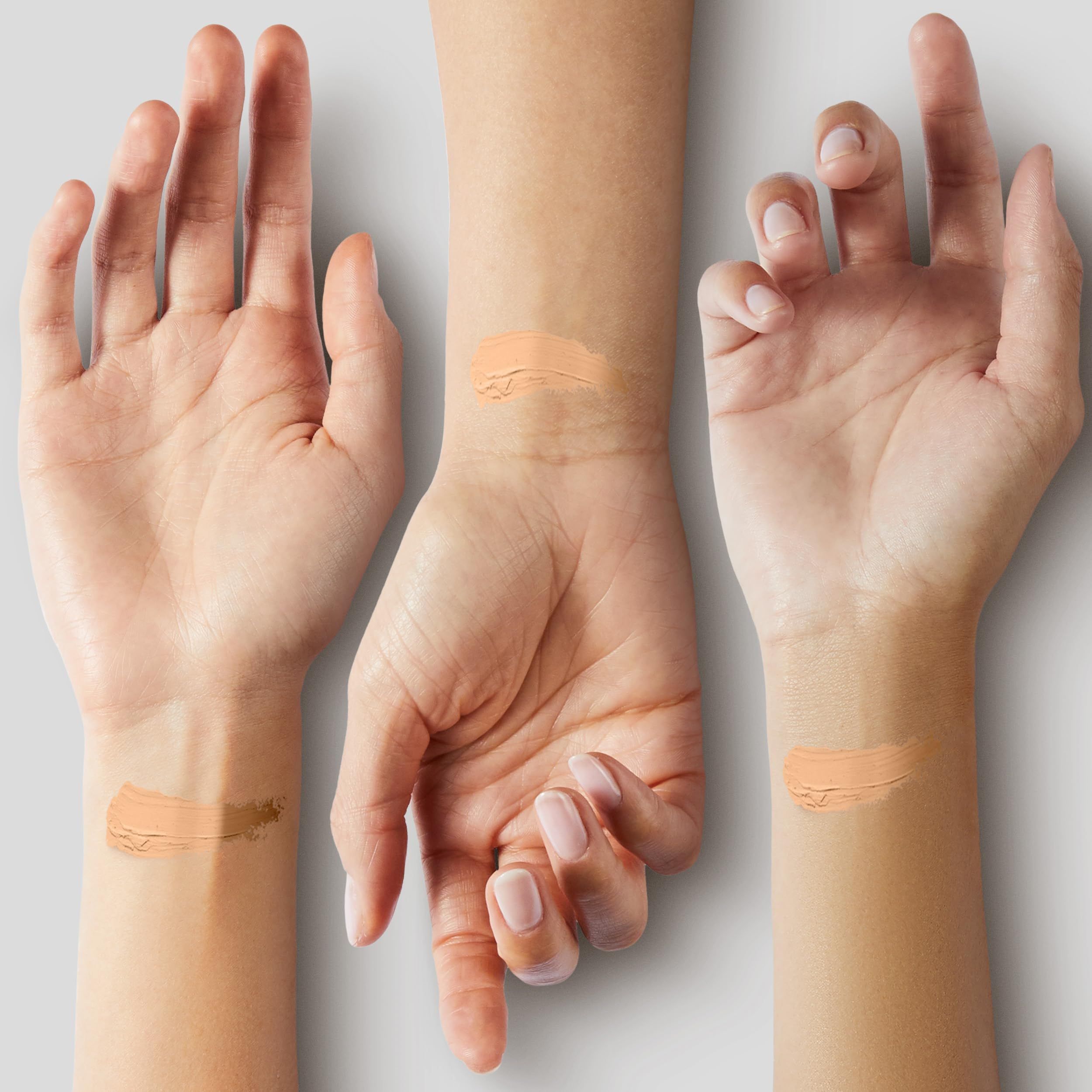 Trois poignets avec échantillons de correcteur. Différents tons de peau. Teintes de produit appliquées.