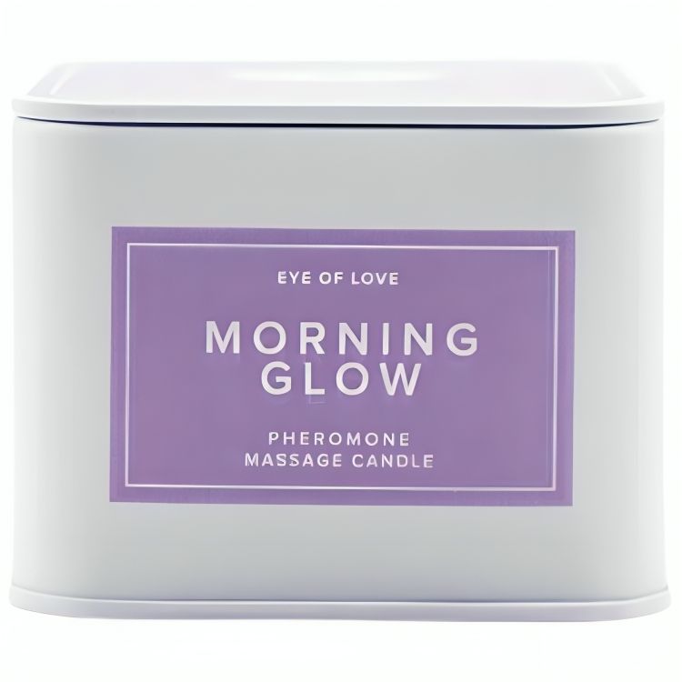 Boîte métallique blanche avec étiquette violette, "Morning Glow Pheromone Massage Candle" par Eye of Love. Couvercle fermé.
