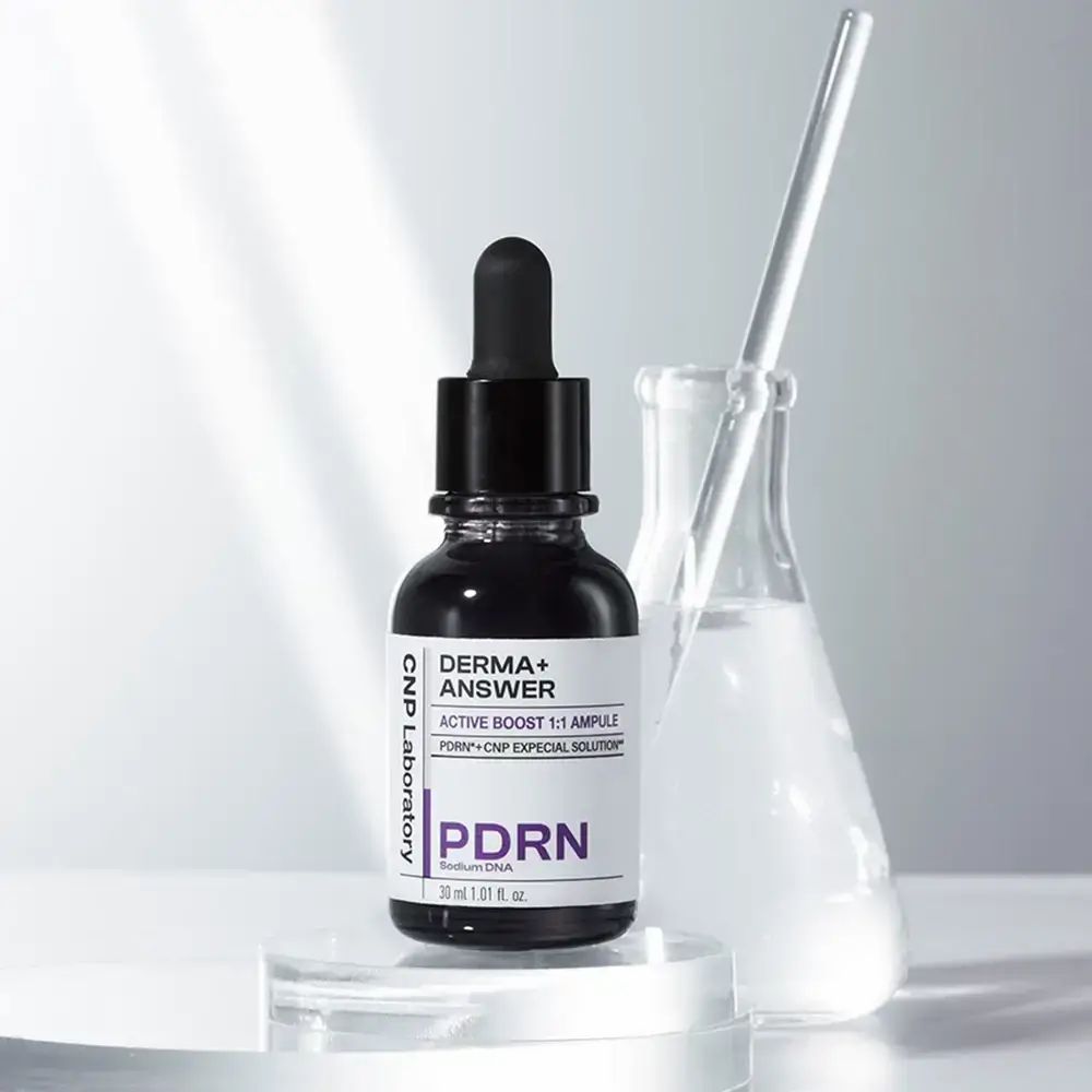 Donkere glazen fles met pipet. Label: DERMA+ ANSWER, PDRN, CNP Laboratory. Glazen container op de achtergrond.