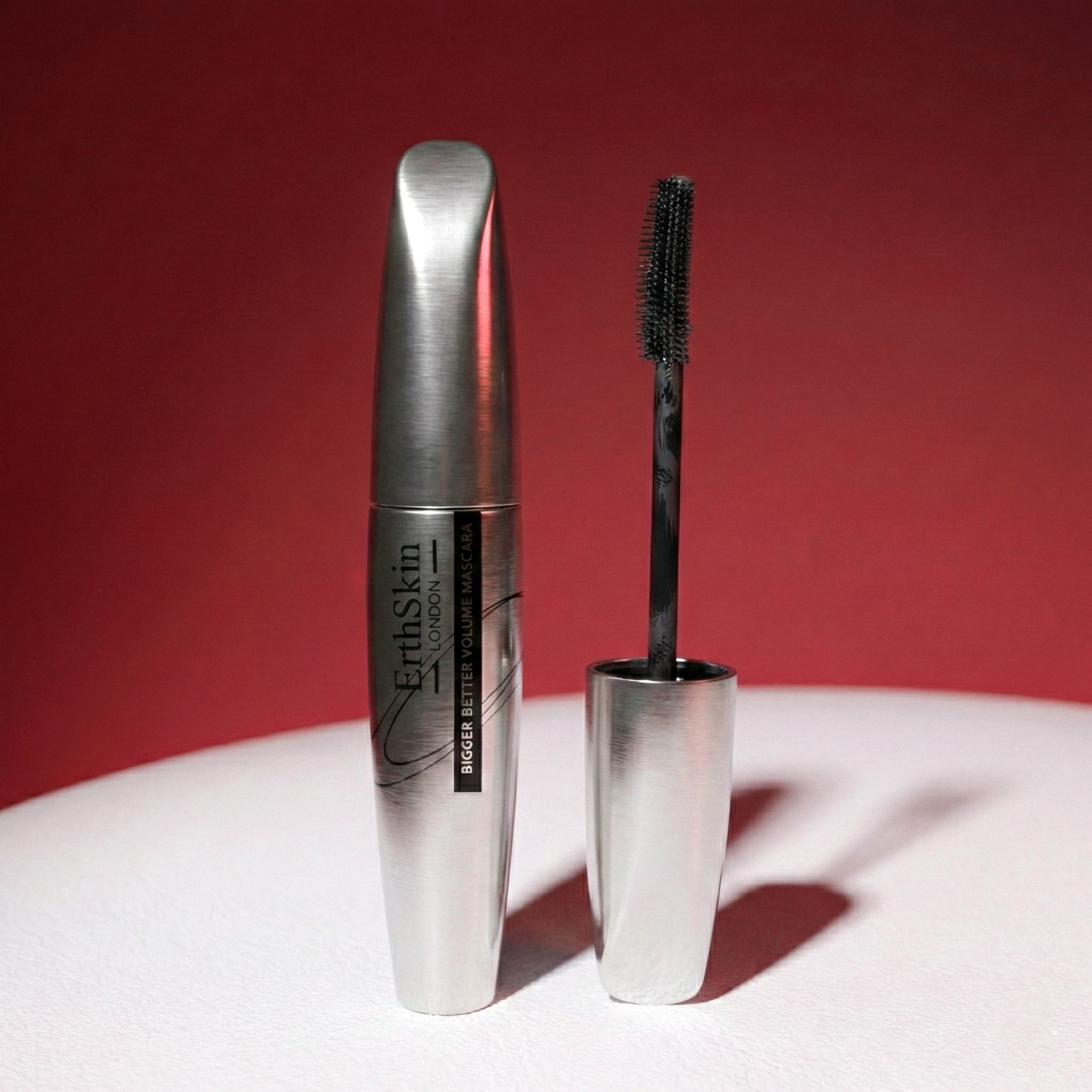 Tube de mascara argenté et applicateur à brosse noire.