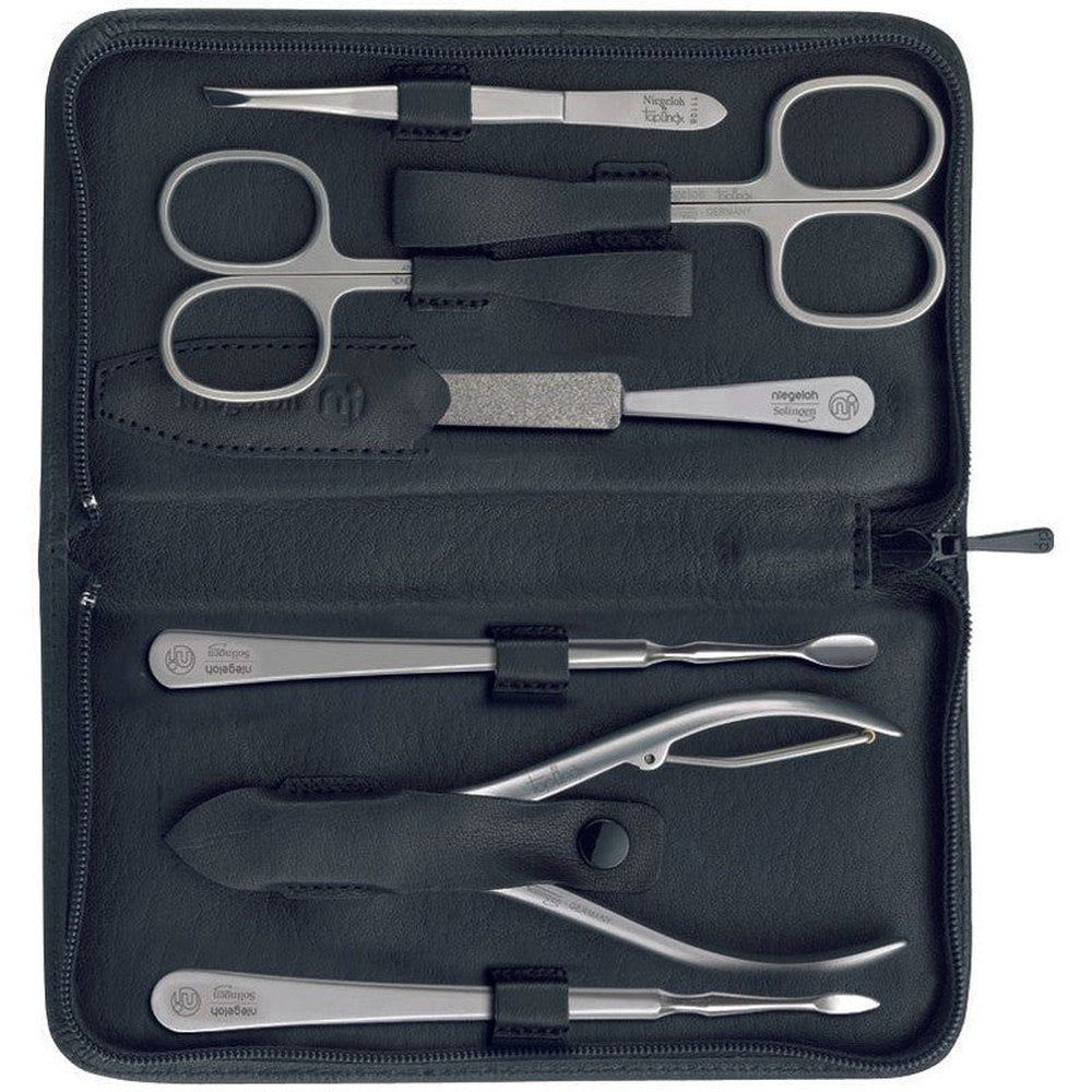Étui noir contenant sept outils de manucure. Ciseaux, pince à épiler, lime à ongles et autres instruments. Niegeloh Solingen.