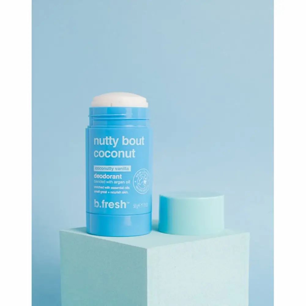 Blauwe deodorantstick met afgenomen lichtblauwe dop. Opschrift: Nutty Bout Coconut, Deodorant, B.fresh. Op een lichtblauw voetstuk.