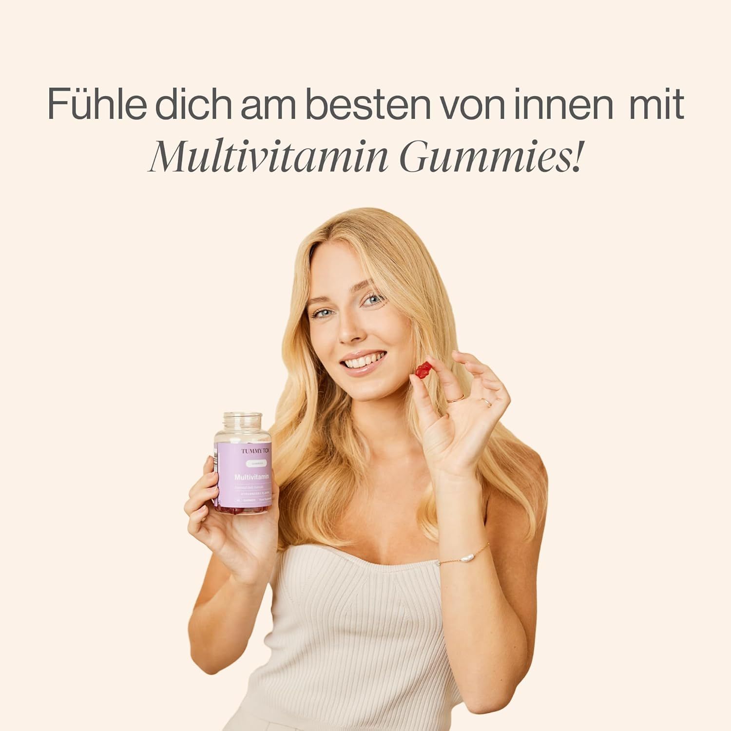 Femme tenant une bouteille et un ours en gélatine. Texte : Gommes multivitamines.