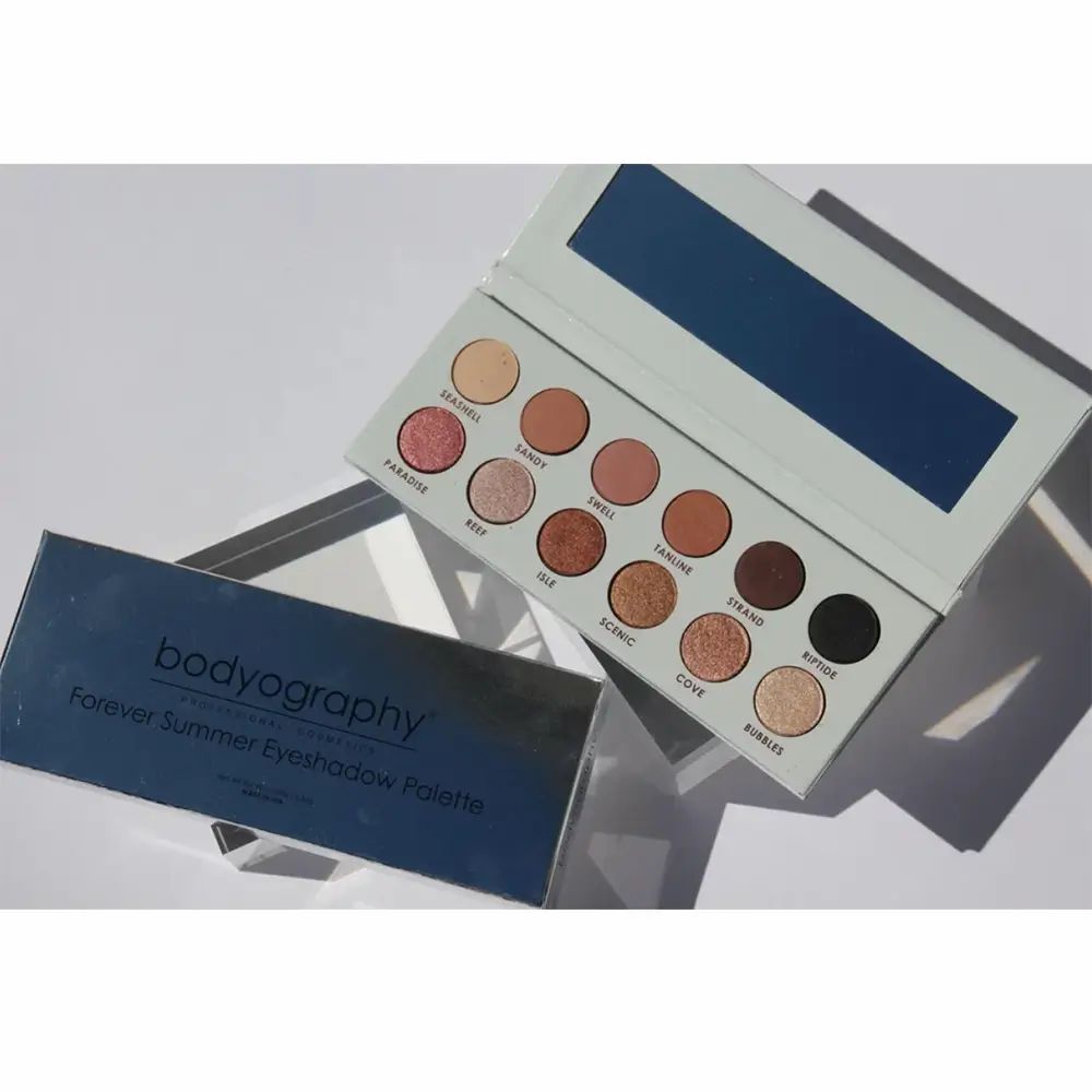 Open oogschaduwpalet met 12 kleuren en spiegel. Blauwe verpakking met opschrift BODYOGRAPHY Forever Summer.