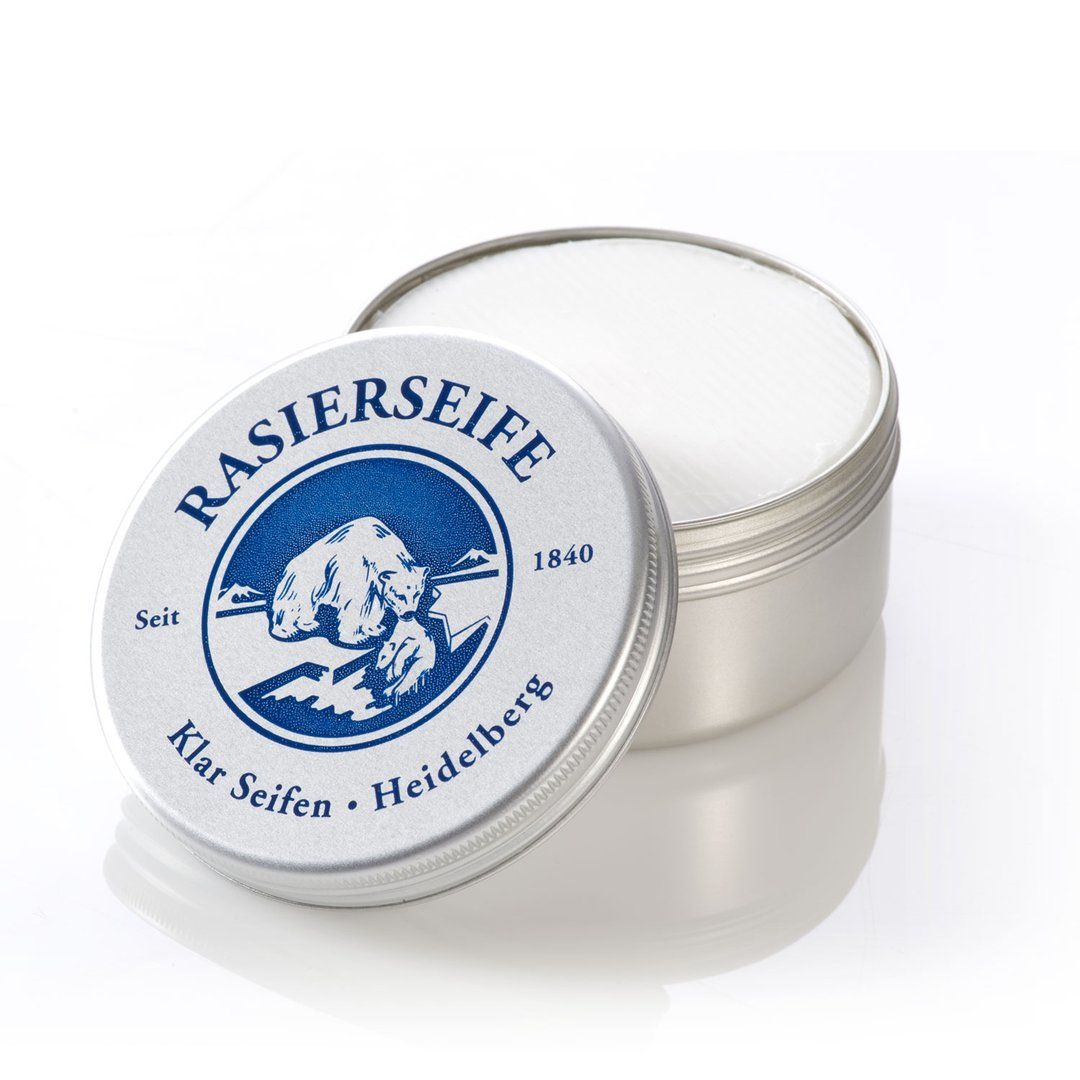 Scheerzeep in blik, deksel open. Op deksel logo en tekst: Rasierseife, Klar Seifen, Heidelberg. Blik van metaal.