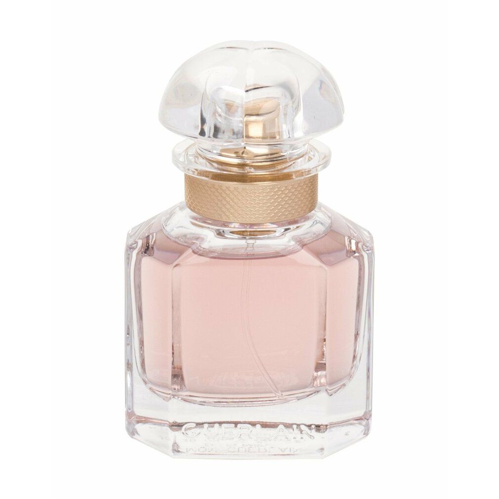 Flacon de parfum carré avec liquide rose, bouchon doré et couvercle transparent. Forme géométrique.