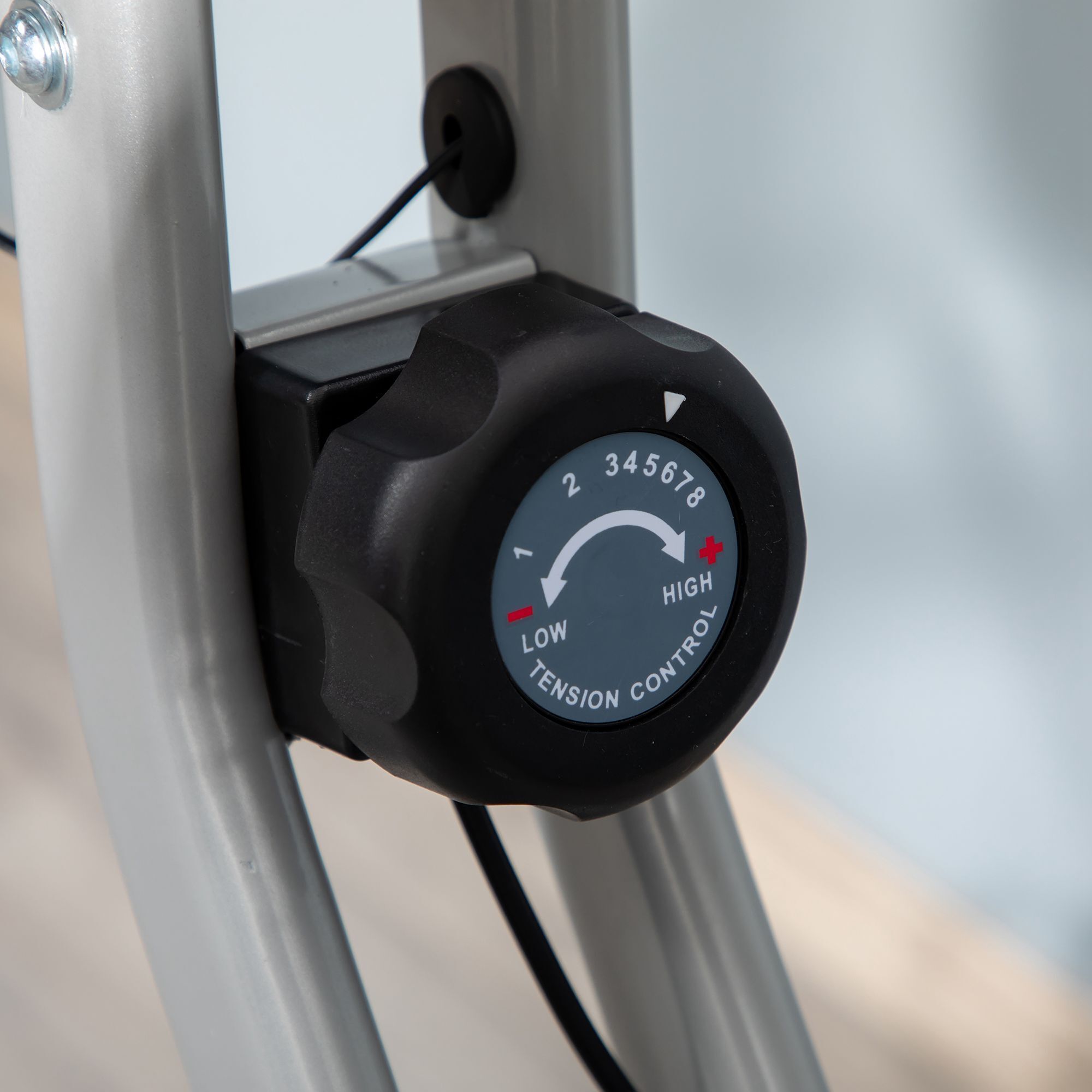 Zwarte draaiknop met cijfers 2-8 en tekst "LOW TENSION CONTROL HIGH".