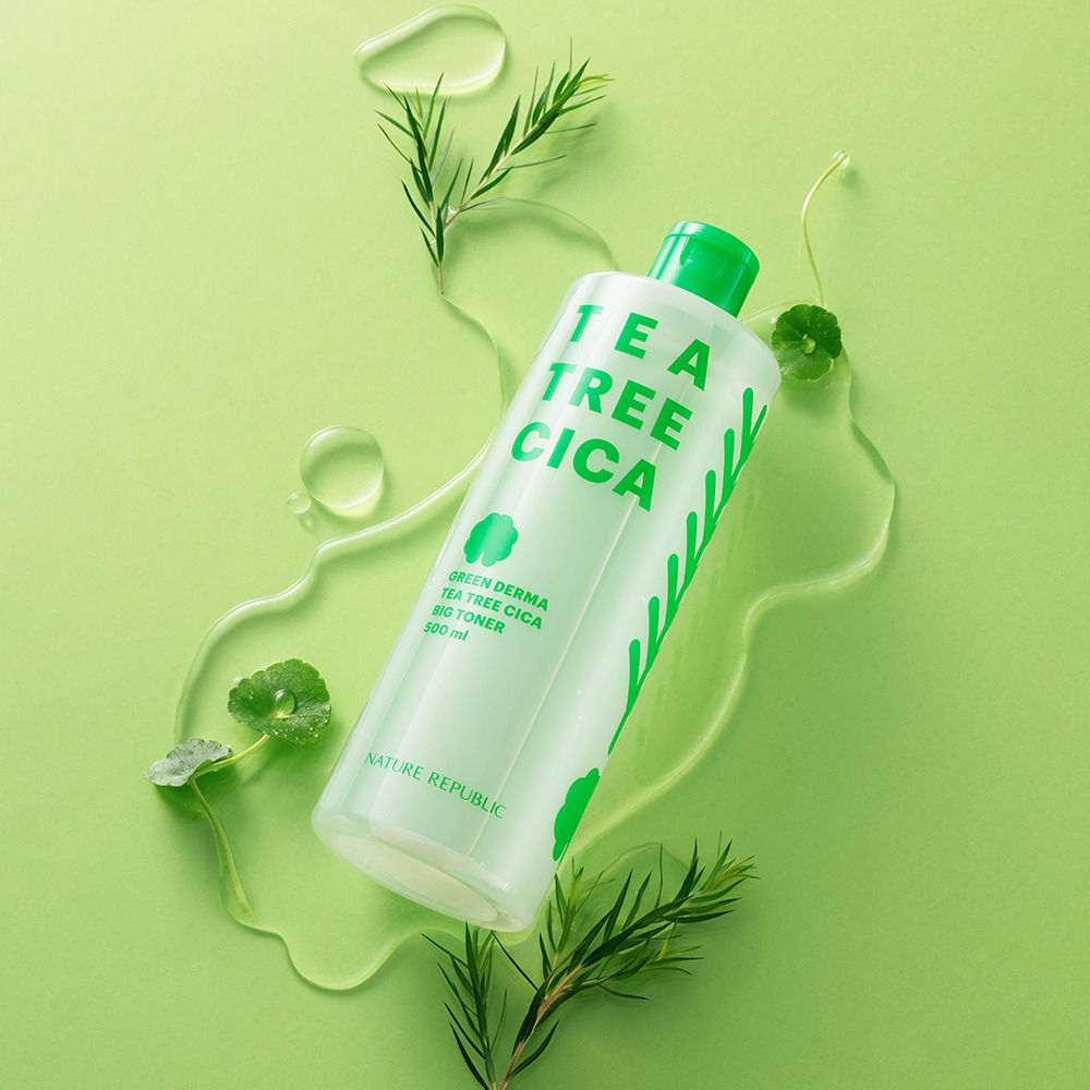 Flacon de toner avec bouchon vert, entouré d'eau et de feuilles vertes. Inscription : TEA TREE CICA, GREEN DERMA, BIG TONER. Marque : NATURE REPUBLIC.