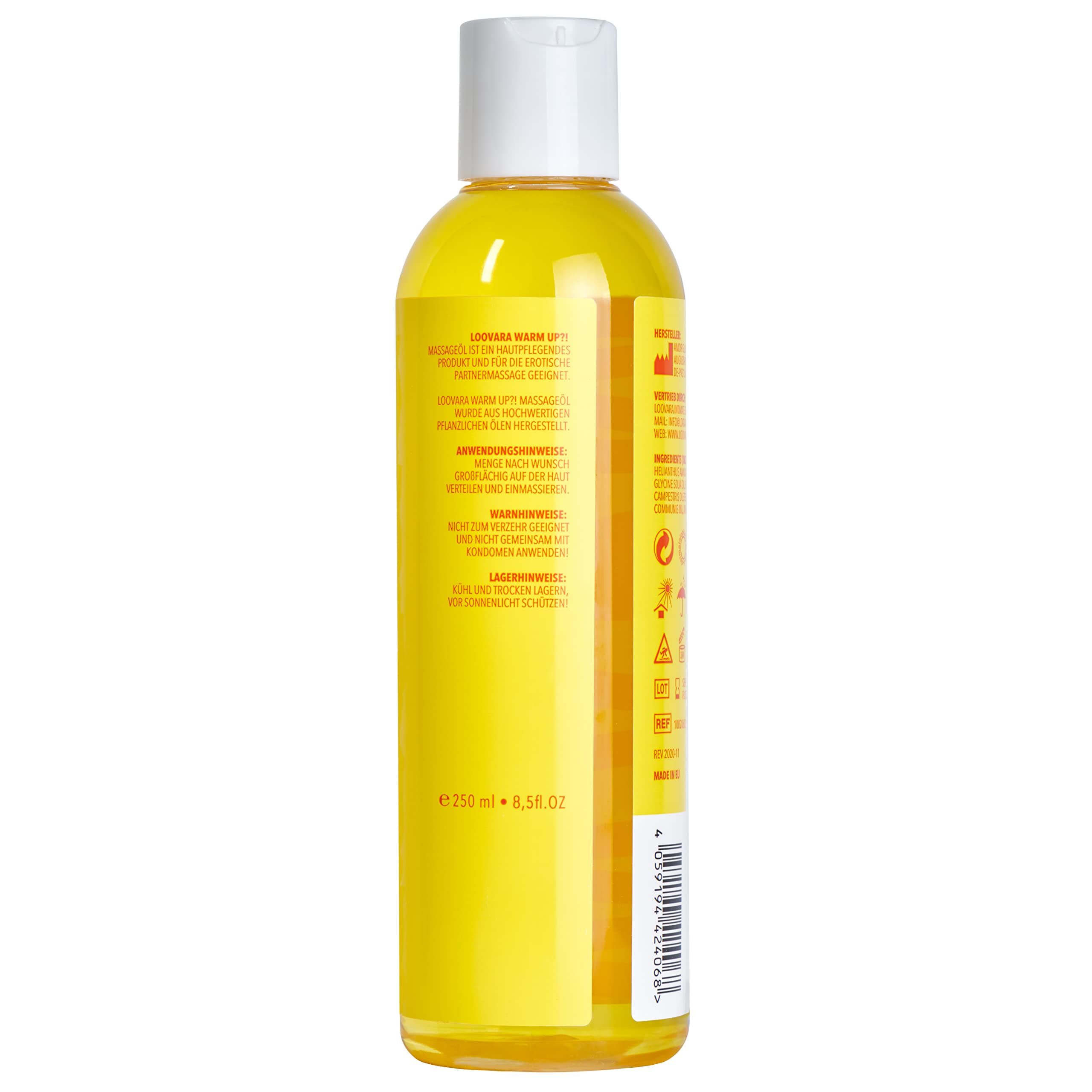 Fles Loovara Warm Up massageolie met geel etiket, omringd door oliespetters.