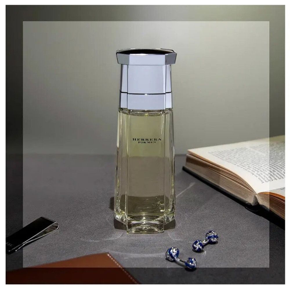 Herrera For Men Eau de Toilette fles op tafel. Boek, manchetknopen, geldclip.