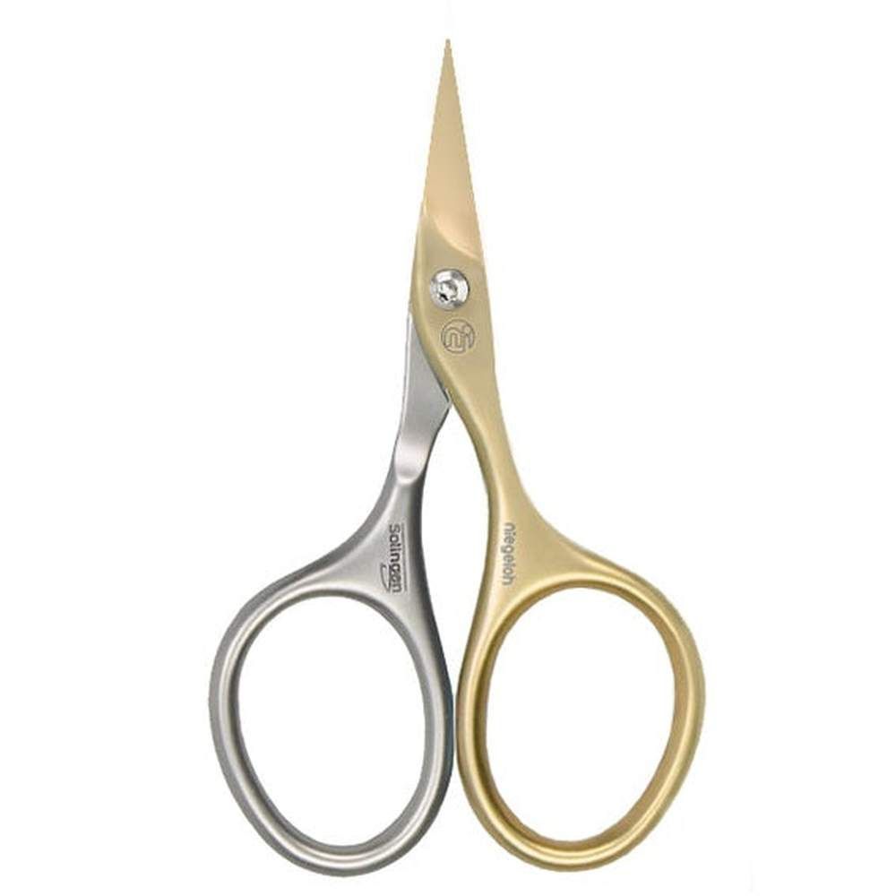 Ciseaux à cuticules avec poignées dorées et argentées. Les marques Solingen et Niegeloh sont visibles sur les poignées.