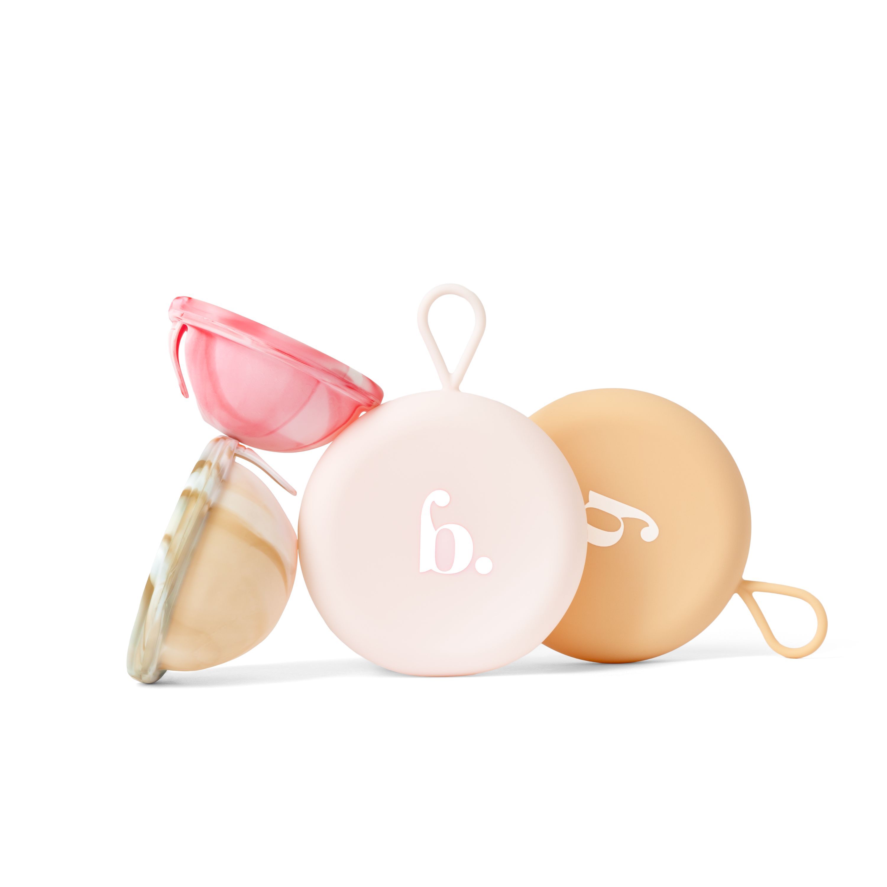 Trois boîtiers ronds avec des boucles, deux de couleur pastel, un ouvert avec un insert.