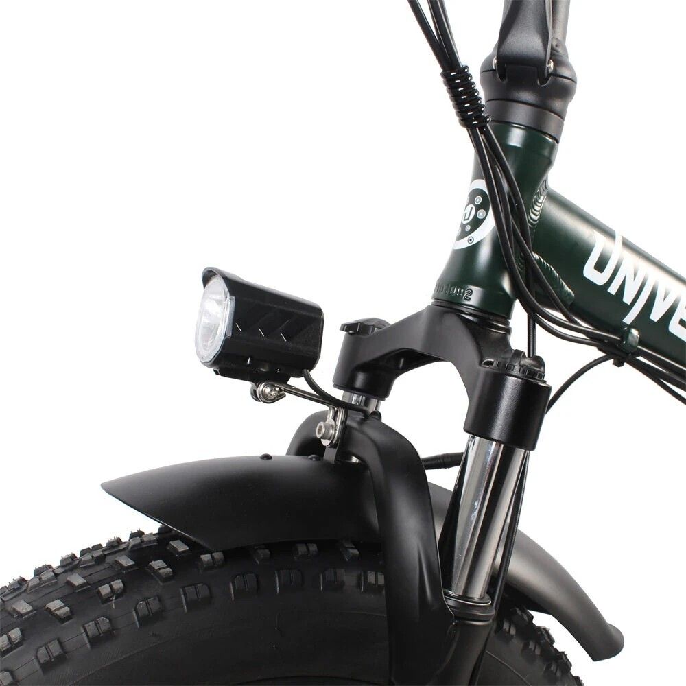 Close-up van de voorvork van een e-bike. Koplamp, spatbord, brede band.