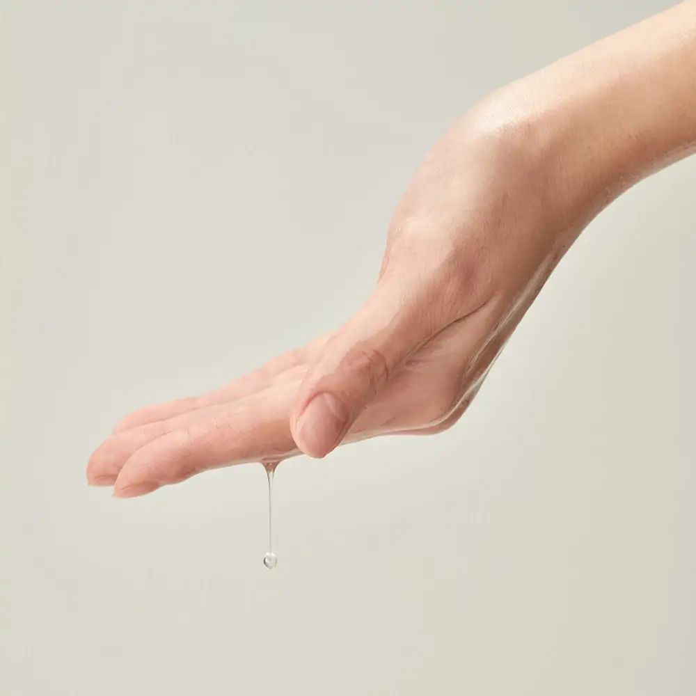 Main avec gouttes de liquide. Le liquide coule de la paume.