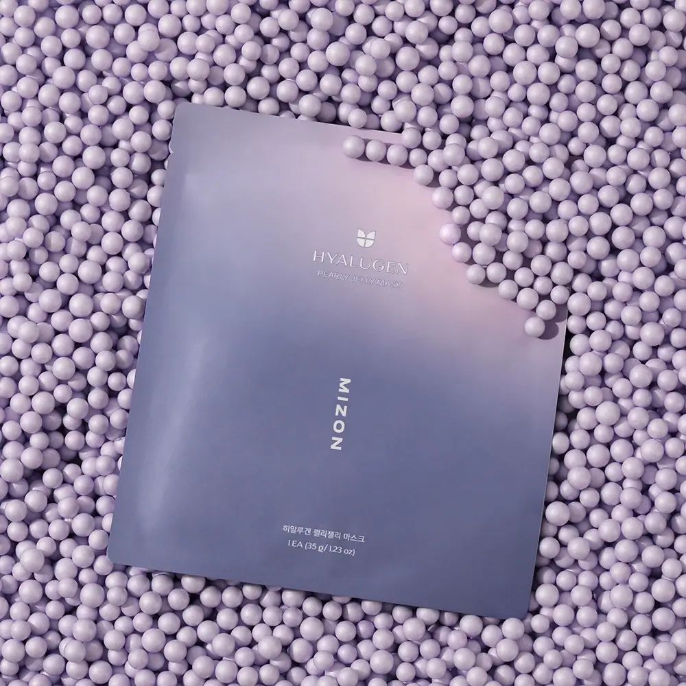 Verpakking van MIZON Hyalugen Pearly Jelly Mask op paarse bollen. Logo en productnaam zichtbaar.