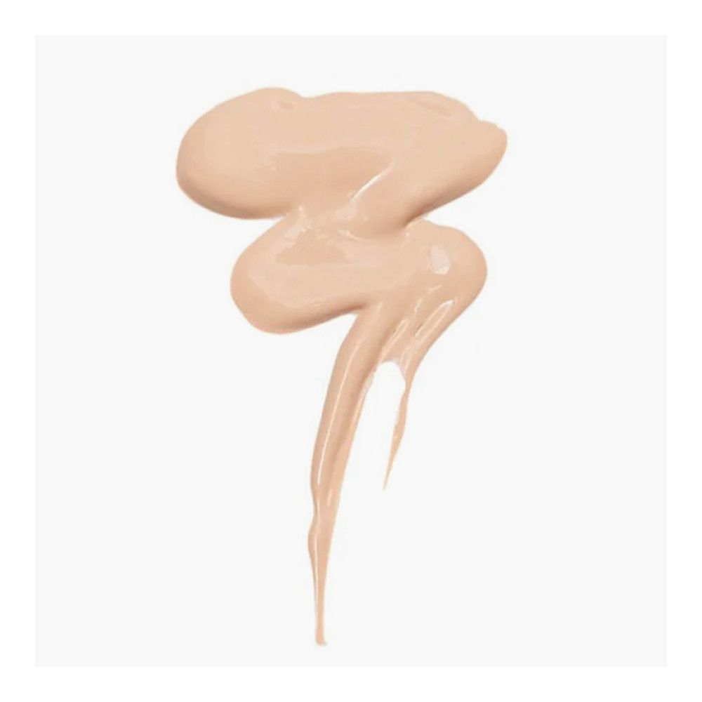 Échantillon de correcteur clair et crémeux sur fond blanc. Texture lisse et brillante.