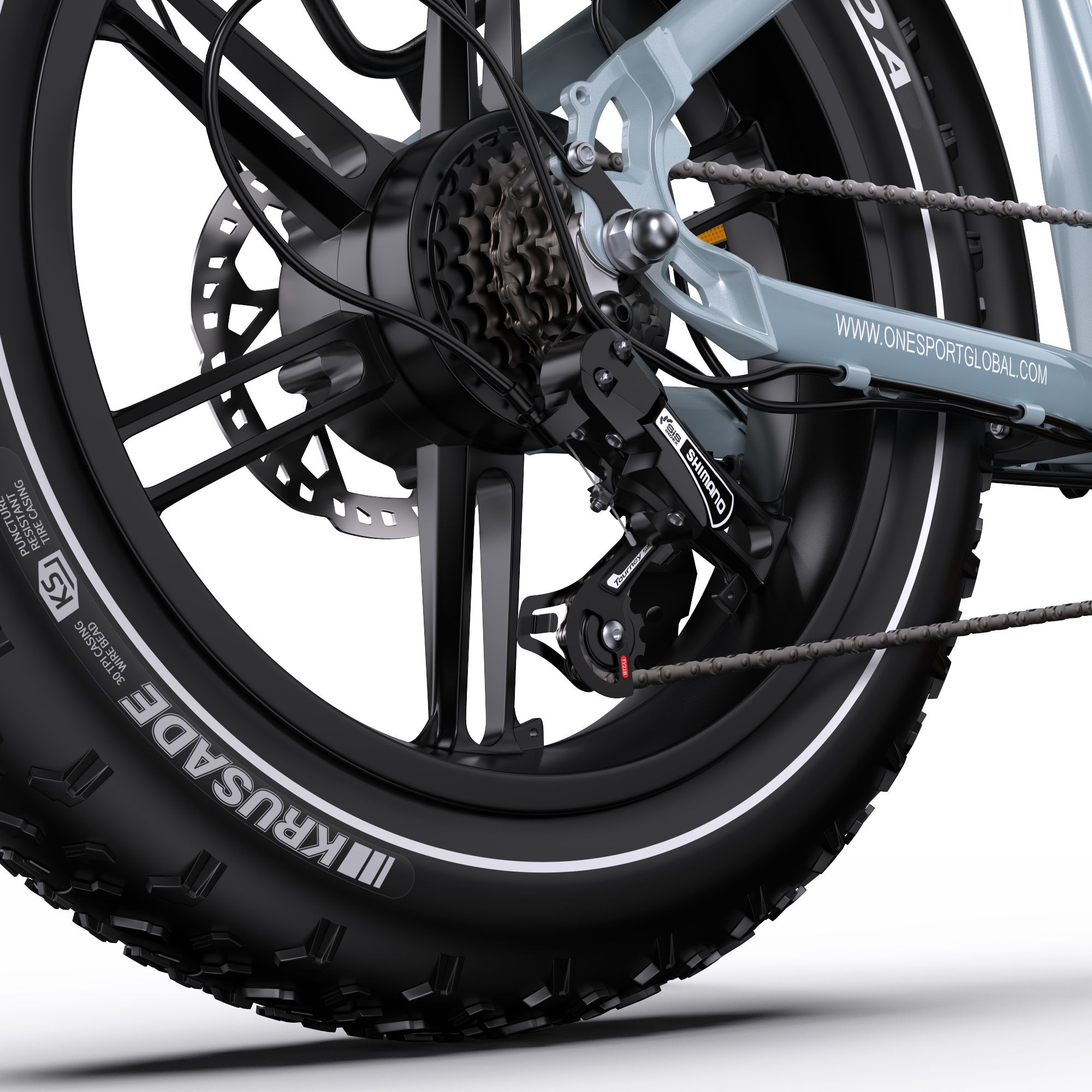 Gros plan sur la roue arrière d'un vélo électrique. Pneus Kenda, dérailleur Shimano, frein à disque.