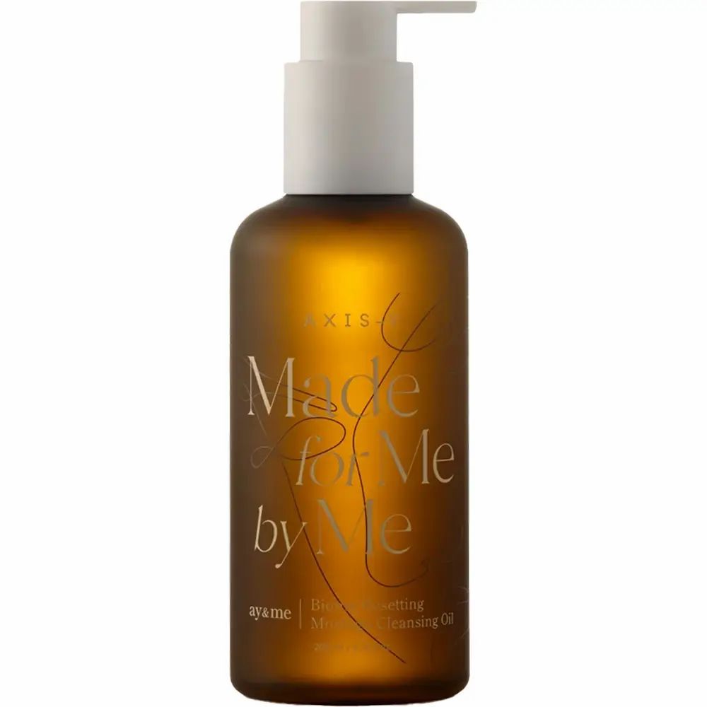 Bruine fles met witte pomp. Opschrift: AXIS-Y, Made for Me by Me, Biome Resetting Moringa Cleansing Oil.