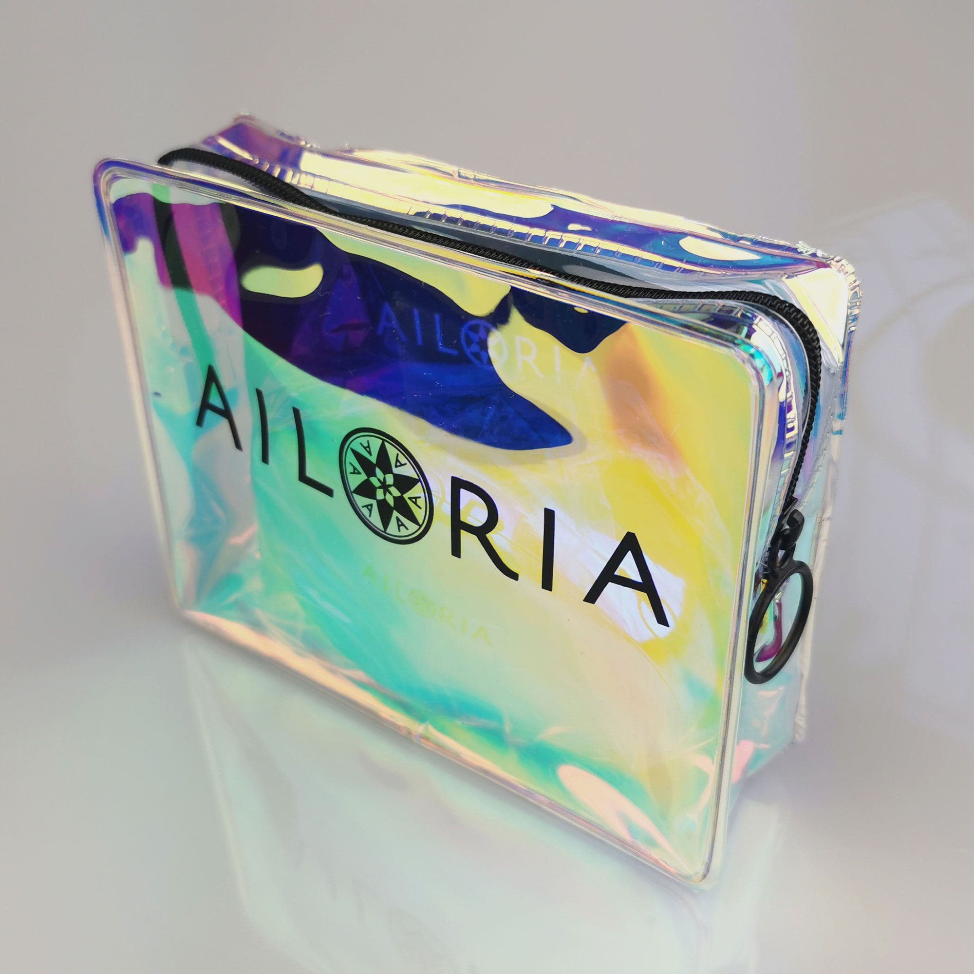 Pochette transparente avec fermeture éclair. Logo AILORIA et symbole de boussole.