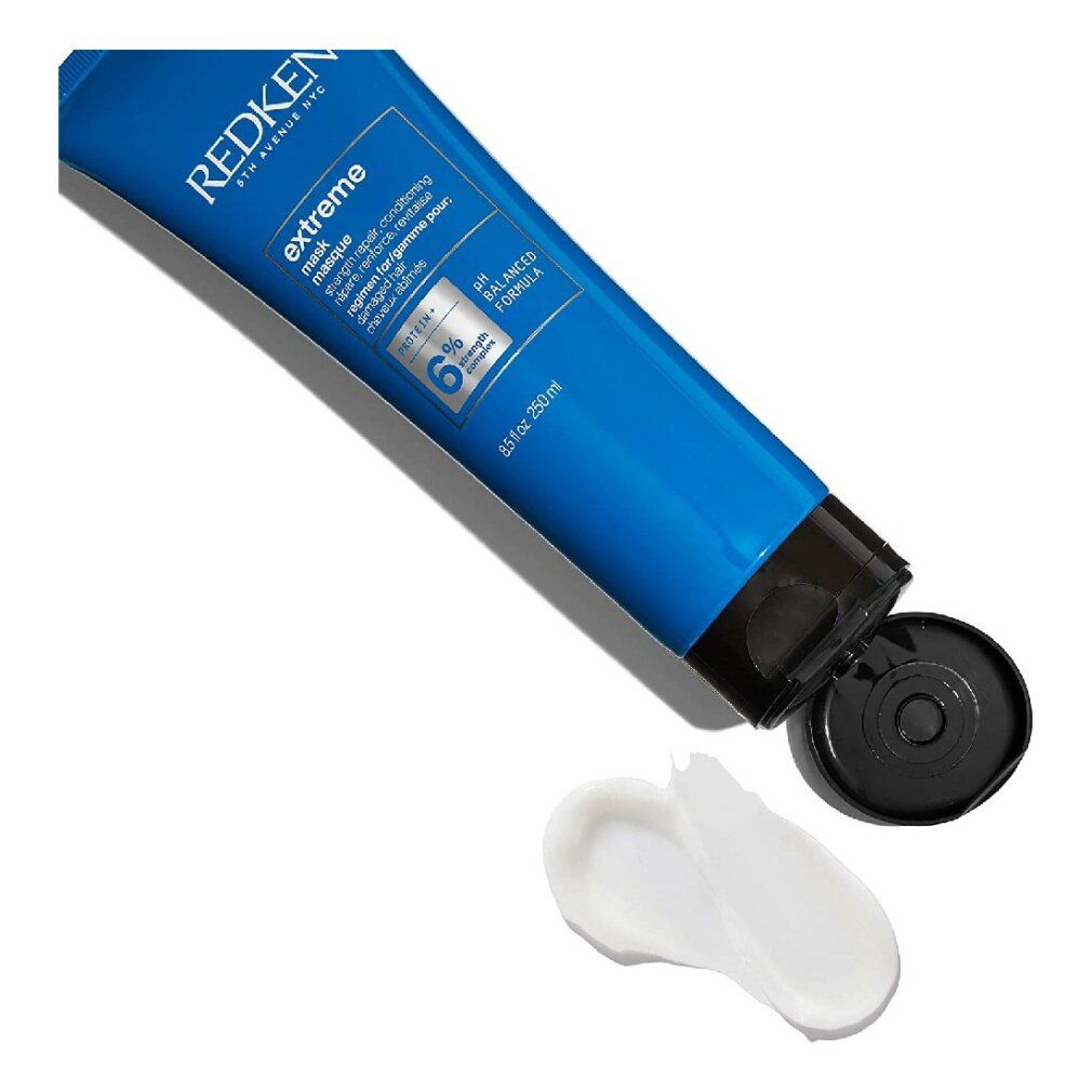 Tube bleu avec produit, le produit est pressé hors du tube. Crème blanche sur fond blanc.