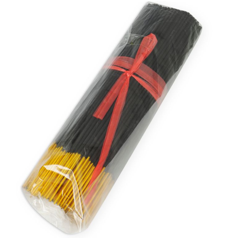 Fagot d'encens noir aux pointes jaunes, lié par un ruban rouge et emballé dans du film plastique.