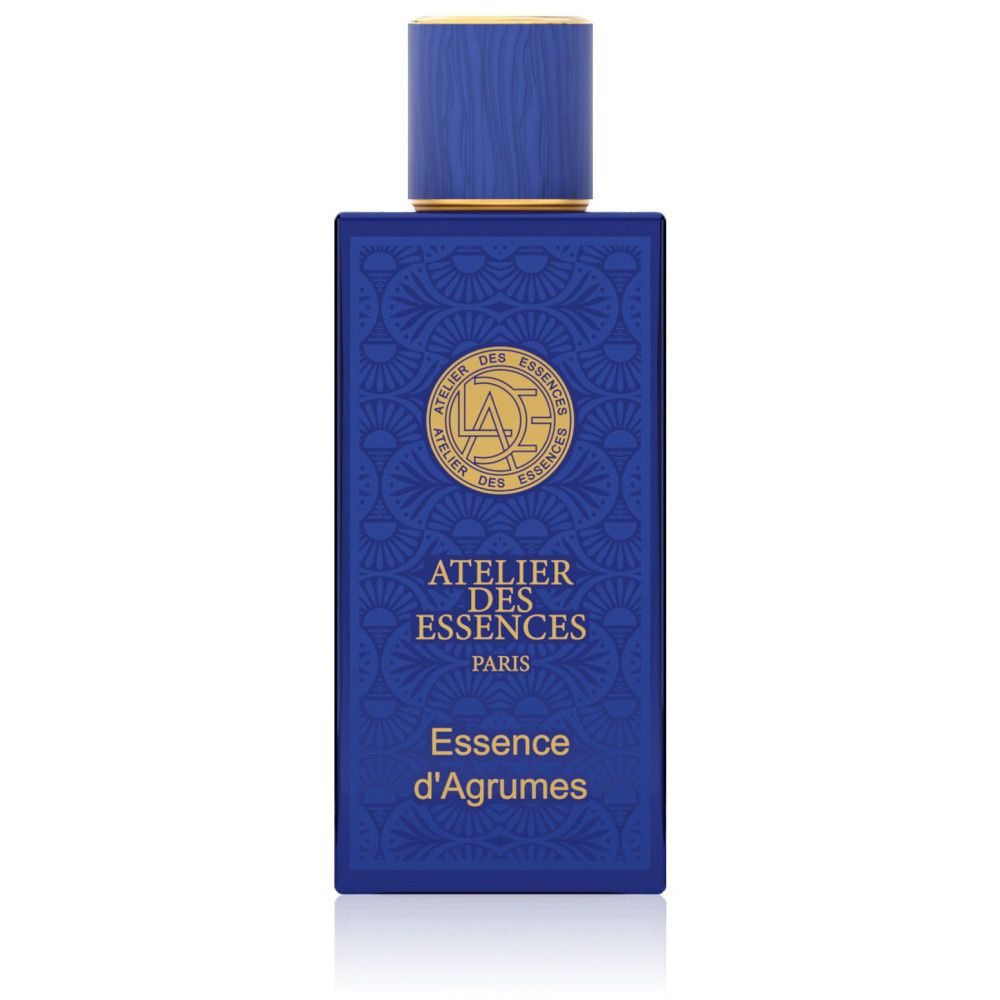 Blauwe parfumfles met gouden details. Tekst: Atelier des Essences, Essence d'Agrumes. Vierkante vorm.