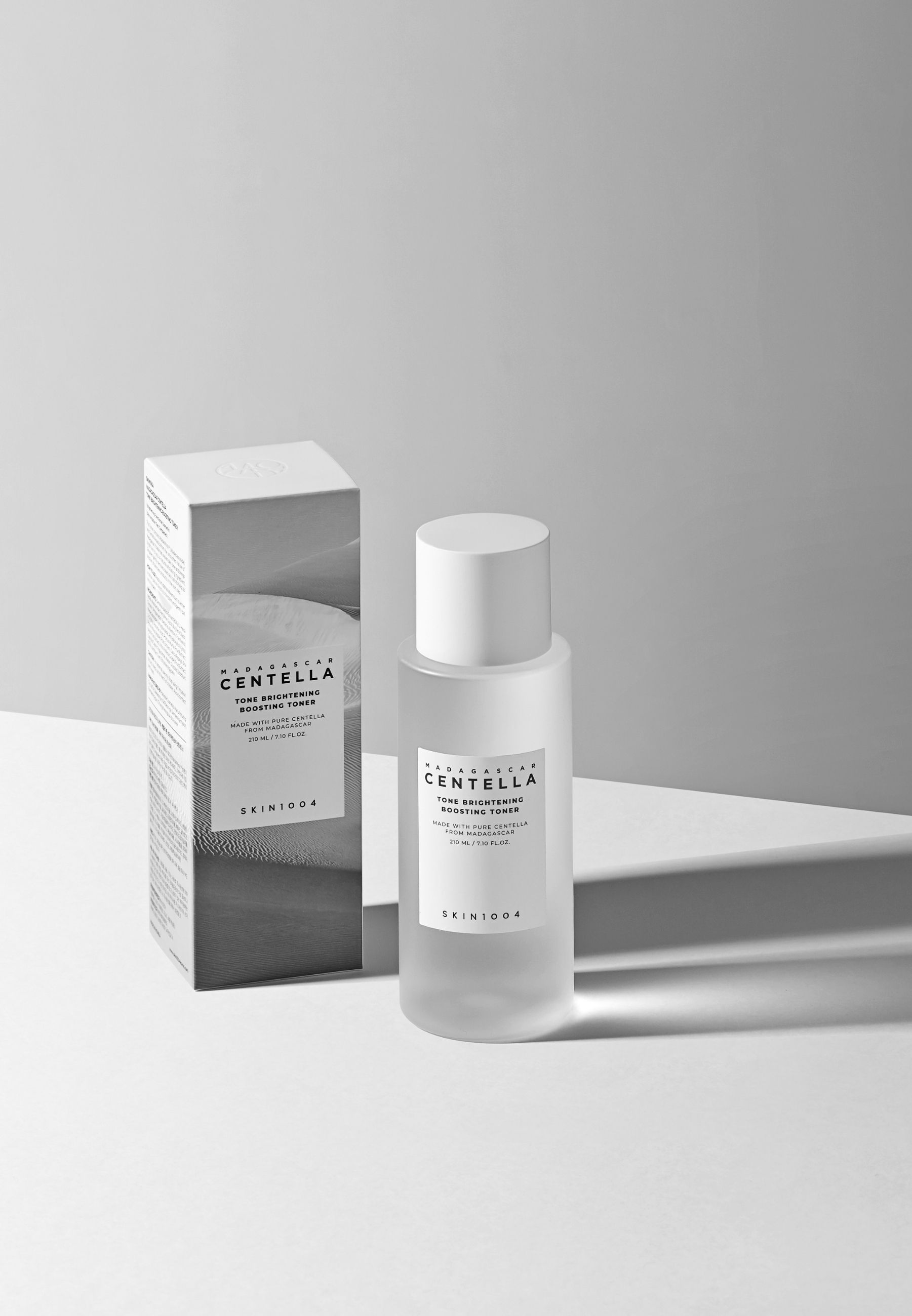 Flacon et emballage du produit. Flacon avec étiquette. Emballage avec nom du produit et marque SKIN1004. Ombre.