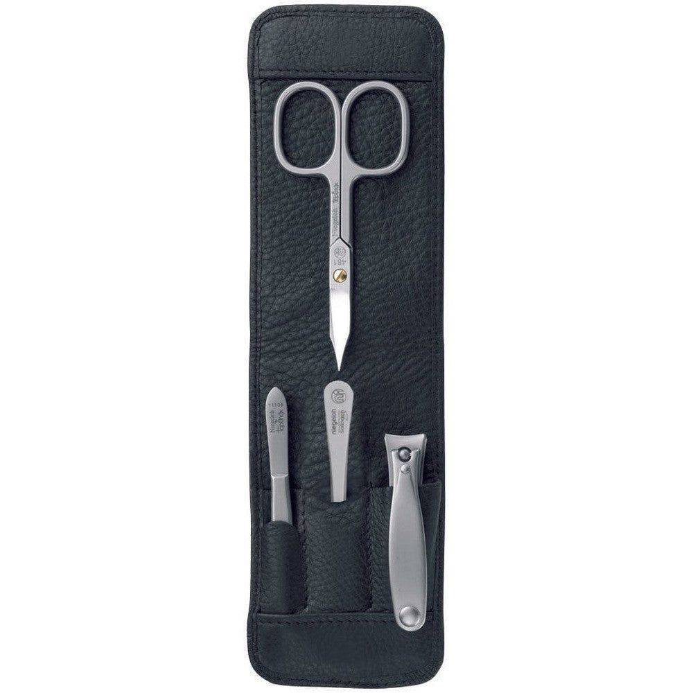 Étui en cuir noir avec set de manucure. Ciseaux à ongles, lime à ongles, pince à peau et coupe-ongles en métal.