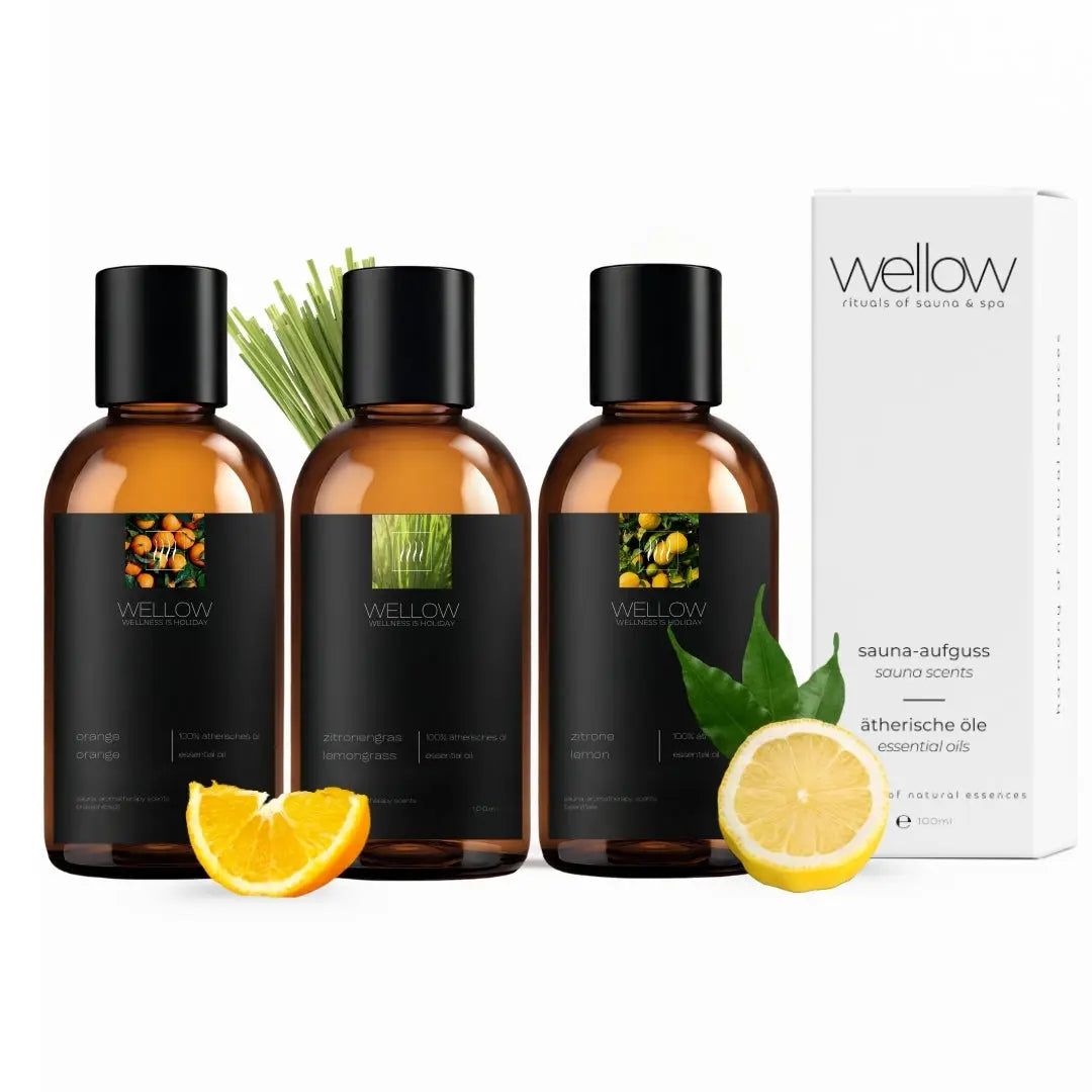 Trois flacons d'huiles essentielles avec étiquettes noires et un emballage blanc. Citron, orange et citronnelle.