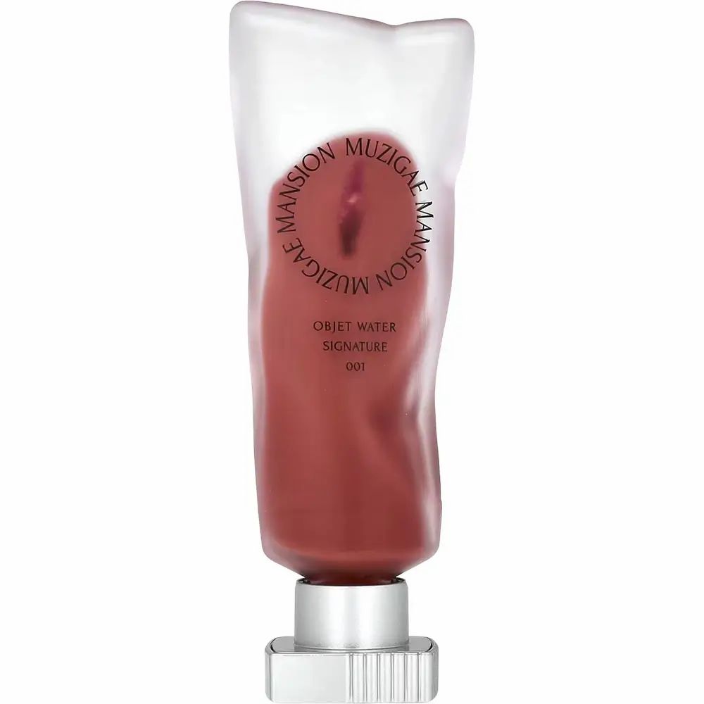 Lip tint in een transparante tube. Opschrift: MUZIGAE MANSION, OBJET WATER, SIGNATURE 001. Zilverkleurige sluiting.