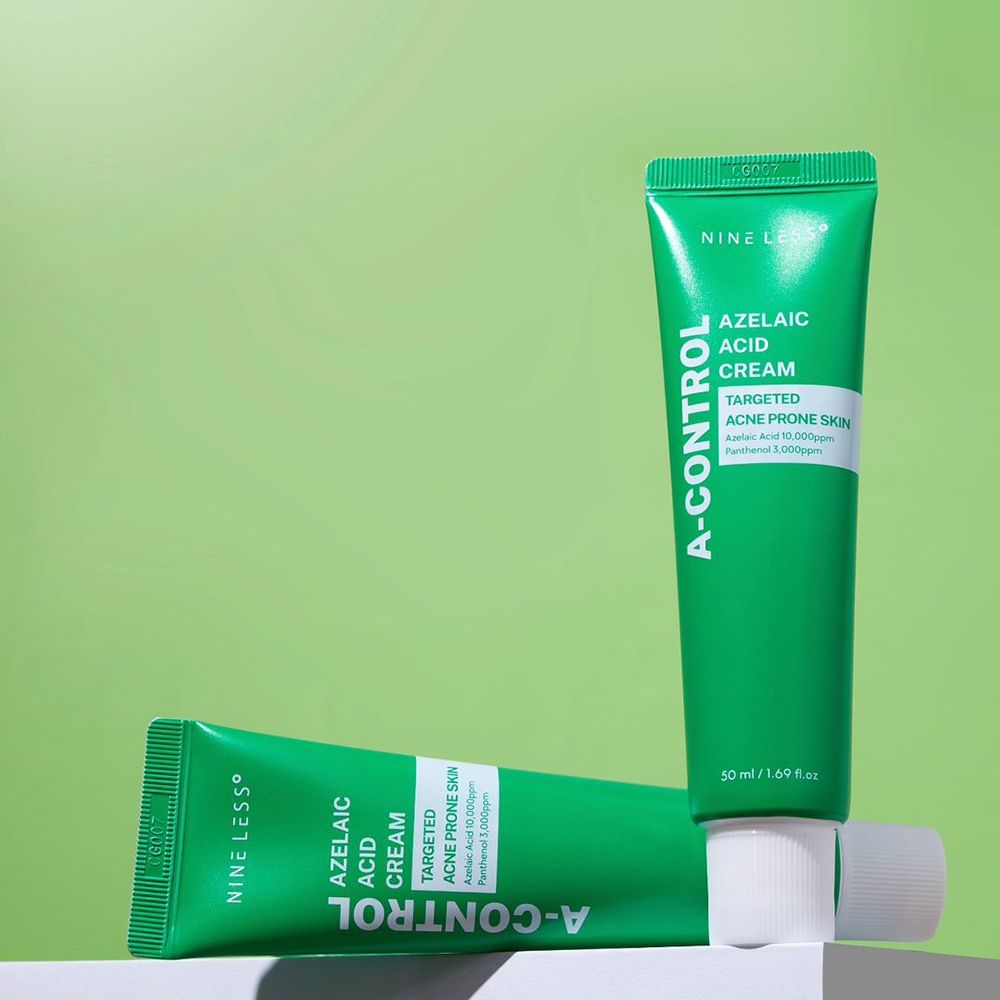 Twee groene tubes met witte dop. Opschrift: A-Control, Azelaic Acid Cream. Eén ligt.