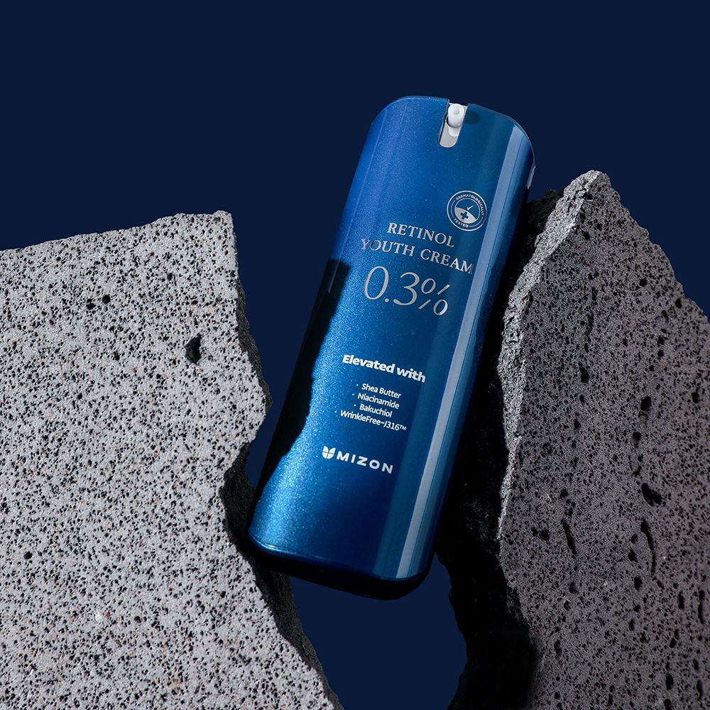 Flacon bleu sur fond gris. Contient Retinol Youth Cream 0,3%. Avec beurre de karité, niacinamide, bakuchiol et WrinkleFree-j316™.