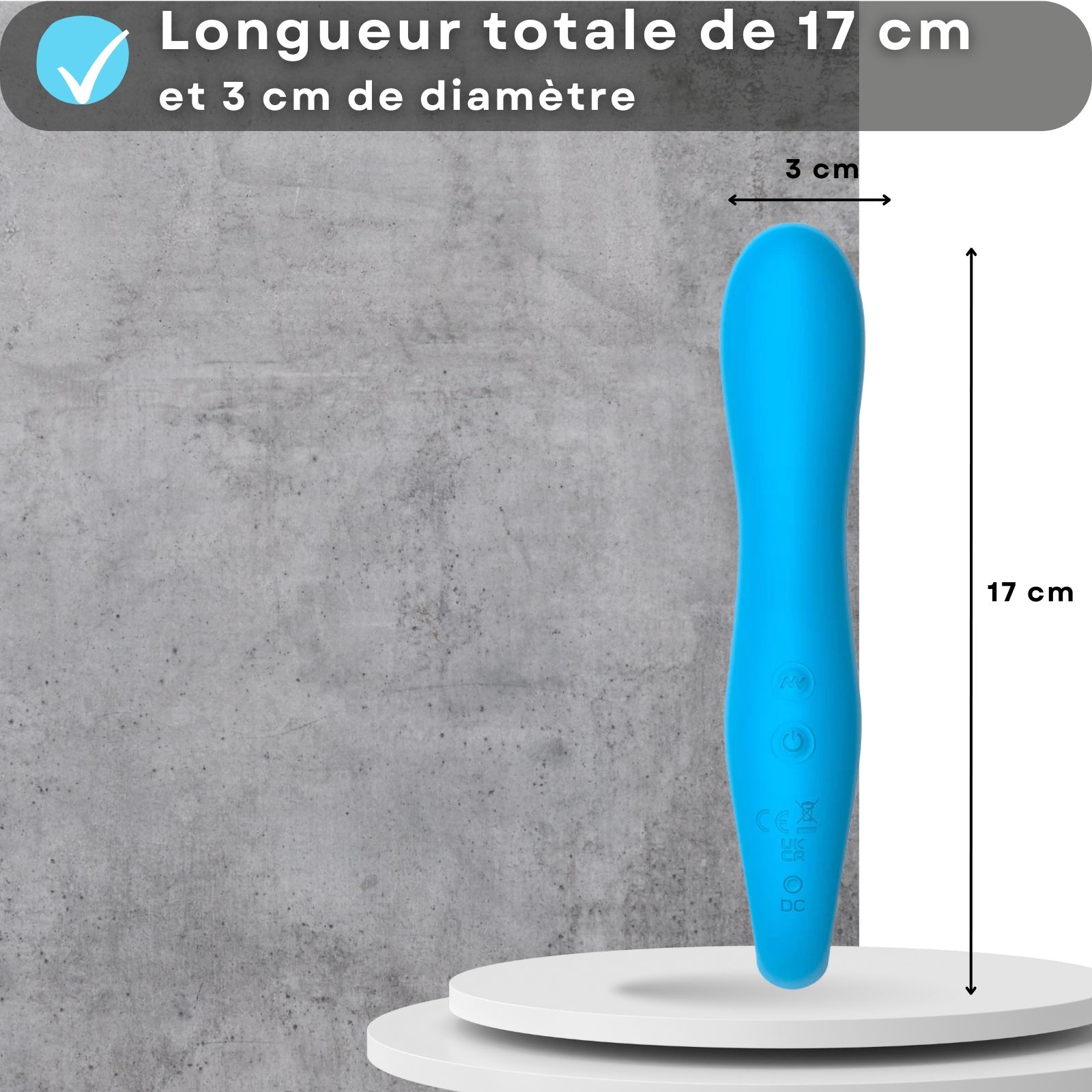 Vibromasseur bleu. 17cm long, 3cm diamètre. Sur socle. Fond gris.