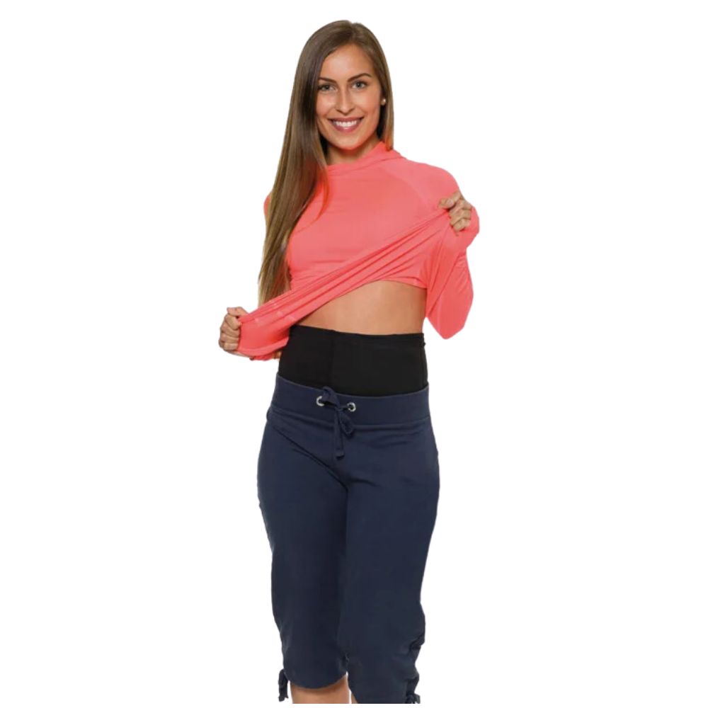 Persoon tilt shirt op, toont zwarte buikband. Band bedekt buikstreek. Persoon draagt sportkleding.