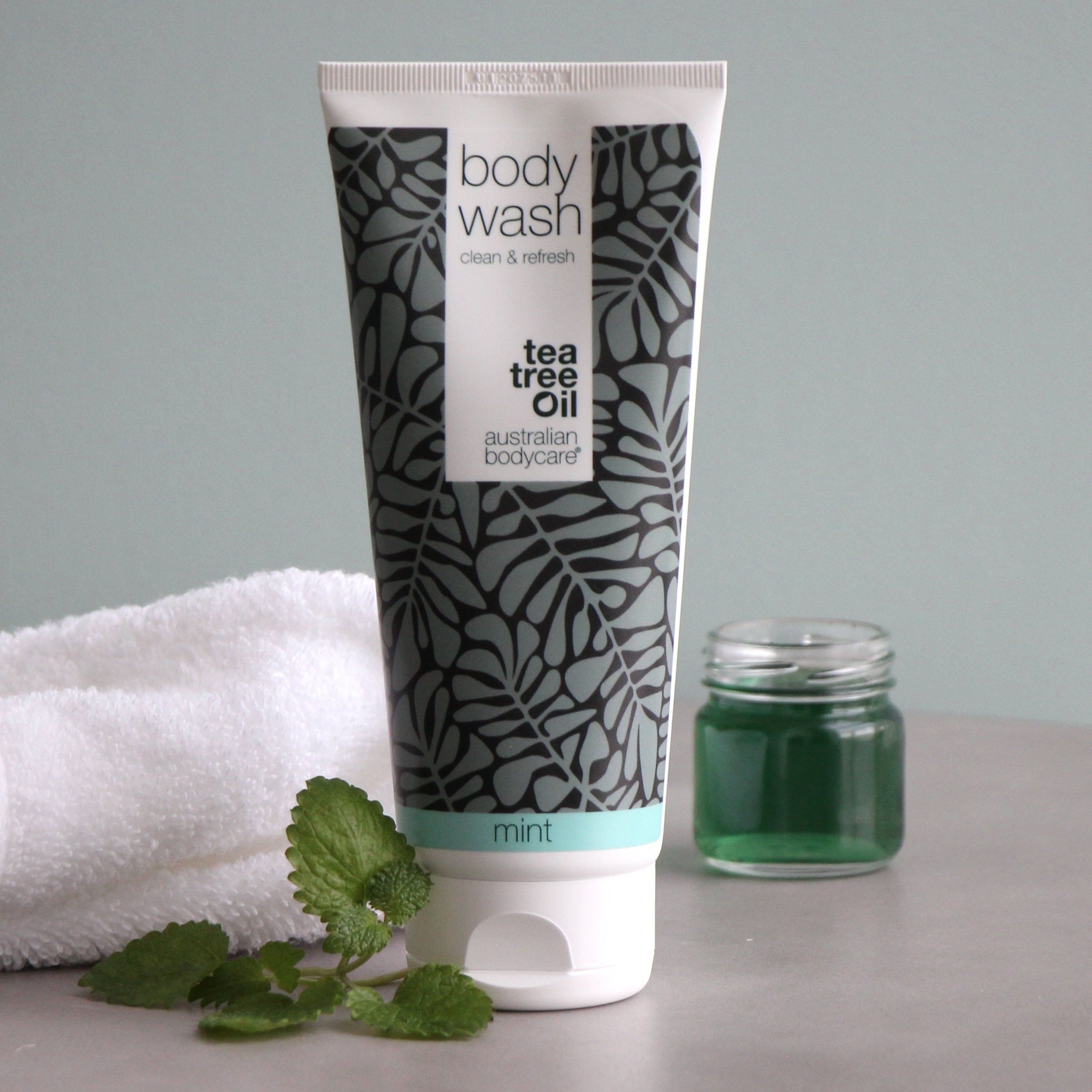 Tube avec « body wash » et « australian bodycare ». À côté, un pot avec du liquide vert.