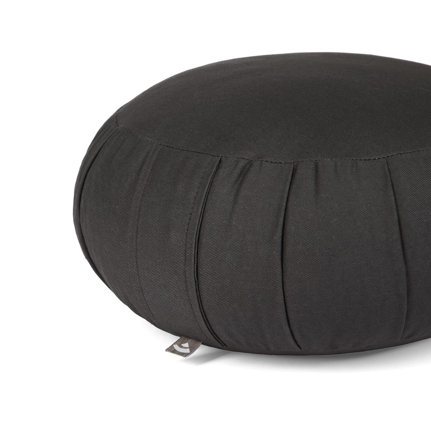 Gros plan sur un coussin de méditation Zafu noir. Plis latéraux. Petite étiquette.