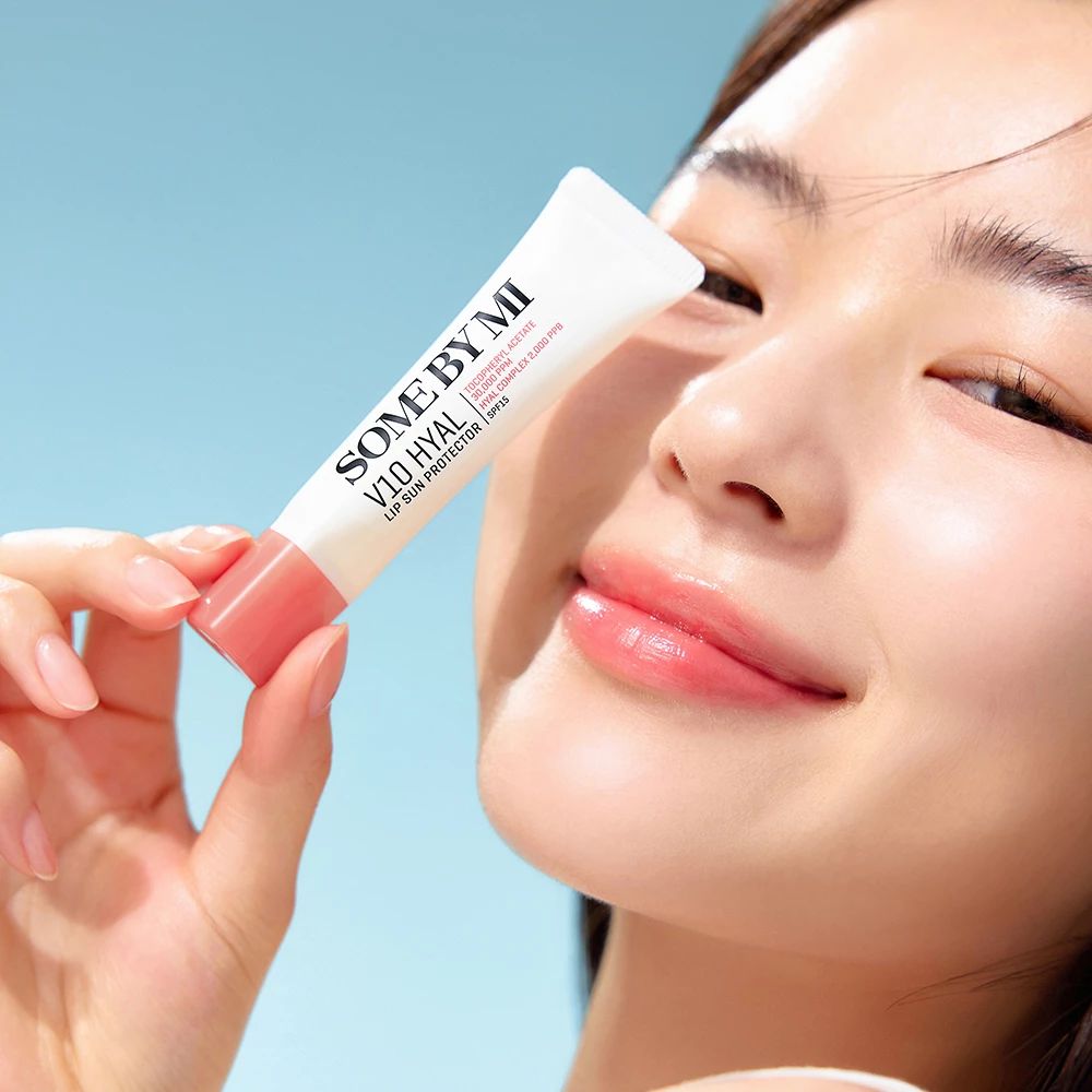 Personne tenant un tube. Le tube porte l'inscription SOME BY MI V10 HYAL Lip Sun Protector SPF15.