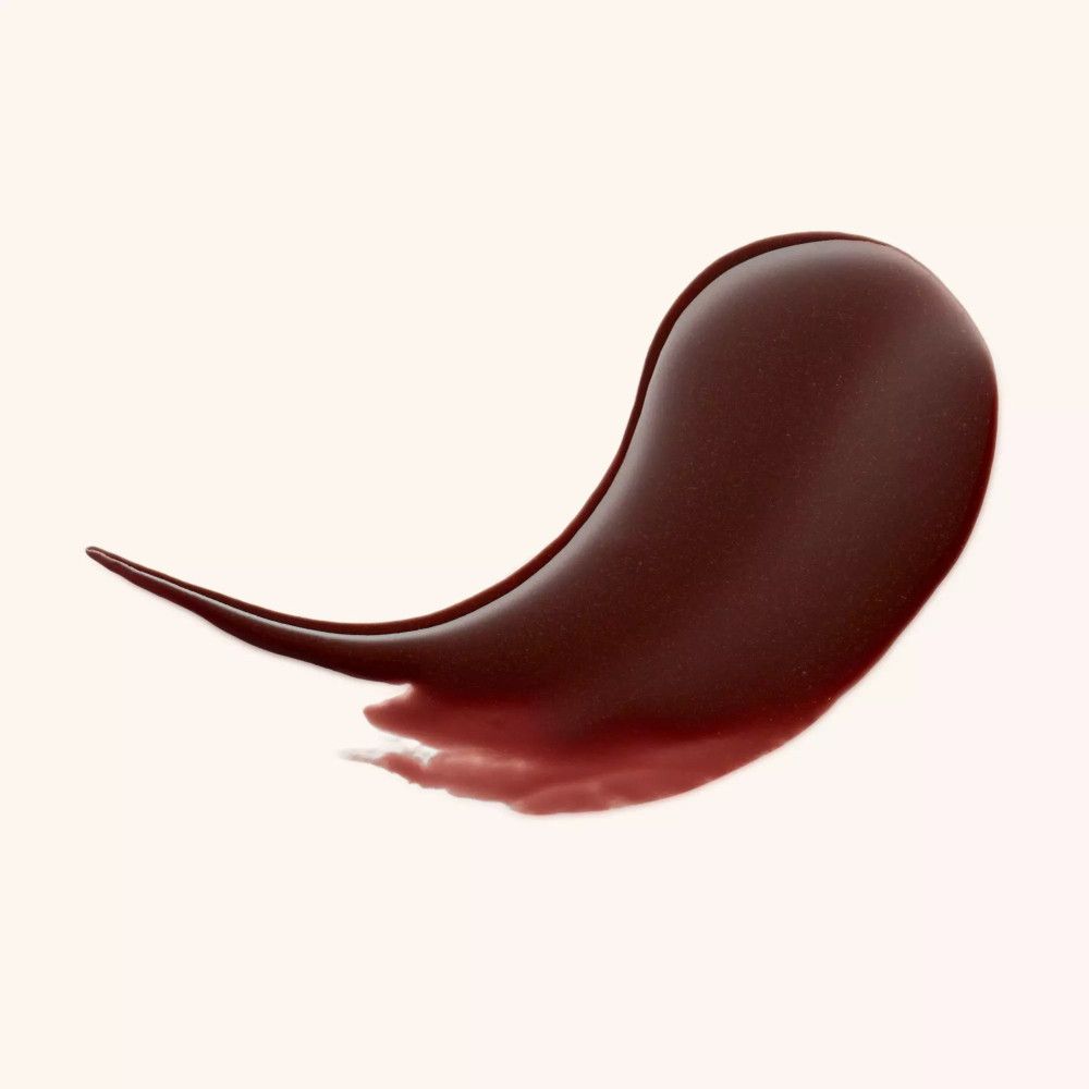 Échantillon de baume à lèvres brun. En forme de goutte, brillant. Sur fond clair.