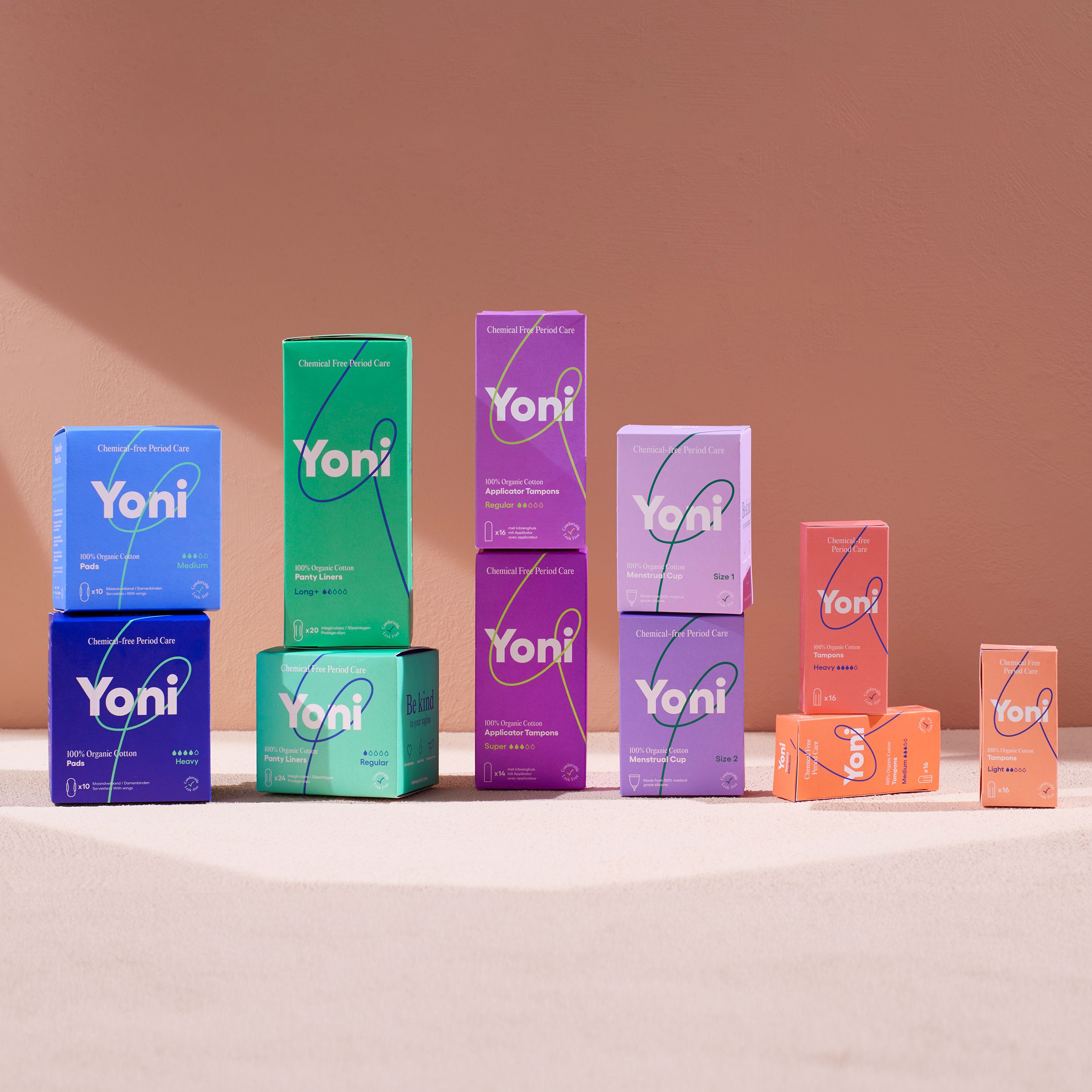 Divers produits Yoni. Emballages de différentes couleurs. Fond rose.