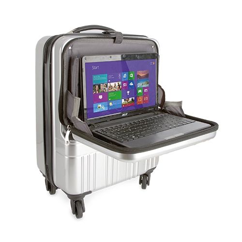 Zilveren trolley met laptop. Laptop op uitklapbaar compartiment. Scherm met Windows-interface.